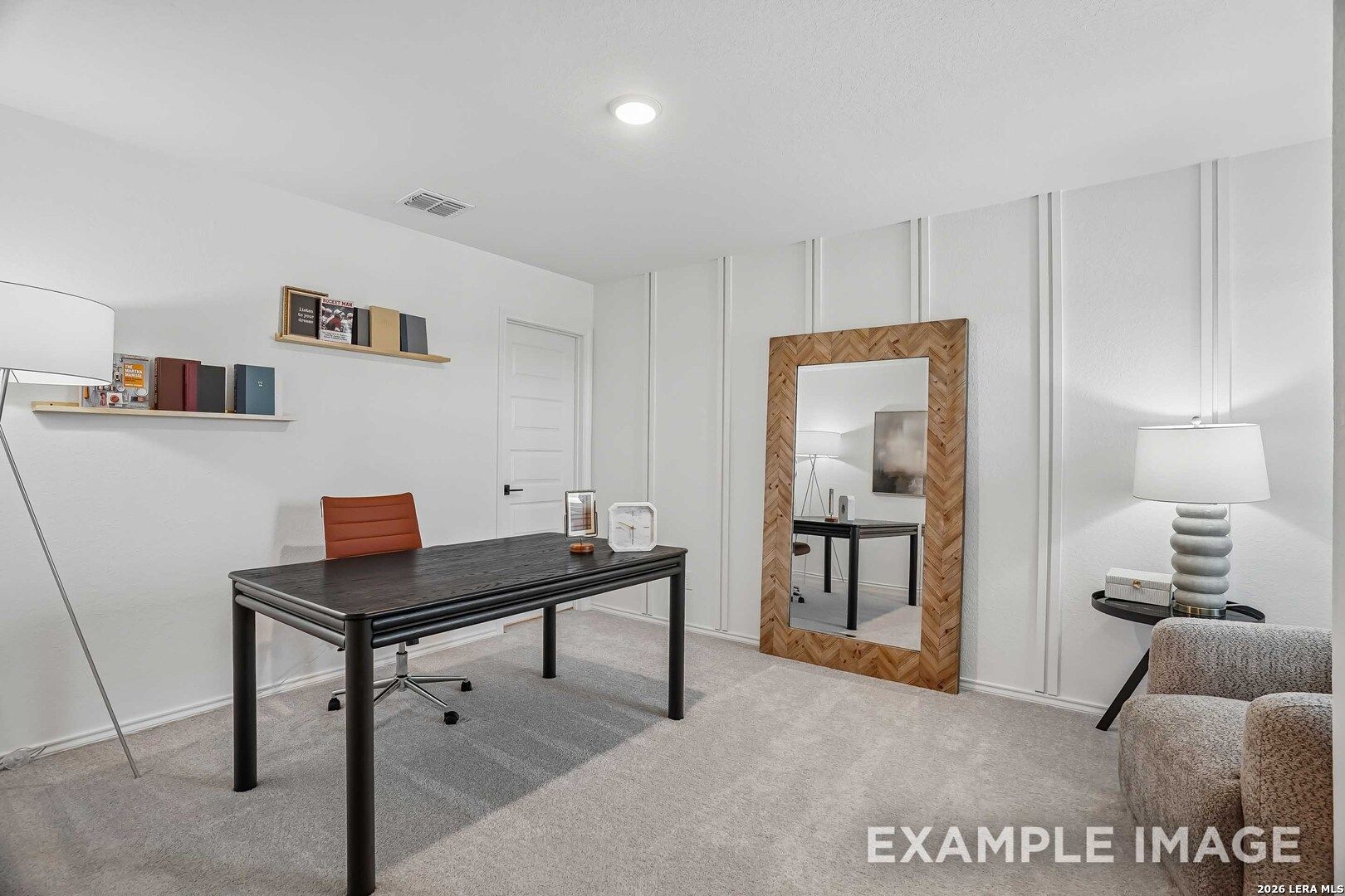 Bright home office with black desk, orange chair, and herringbone wood mirror in Davidson Homes Pinecrest E, Converse, Texas