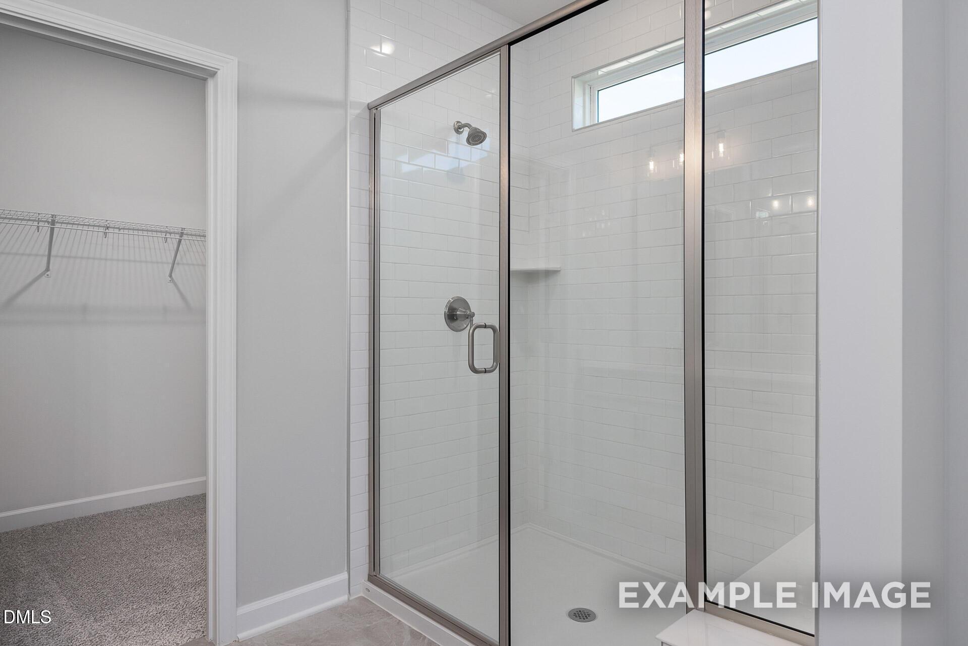 Walk-in tile shower with glass door in The Magnolia A floor plan home at Retreat at North Main in Lillington, NC.