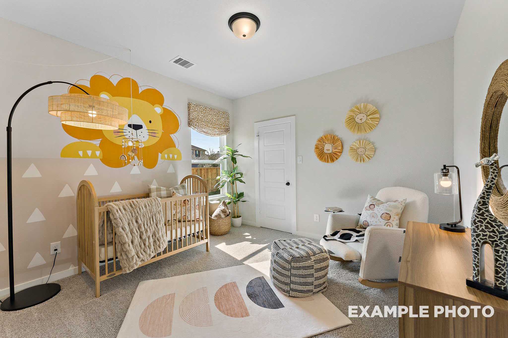 Charming nursery in The Everett E featuring yellow lion wall decal, wooden crib, potted plants, and cozy pouf seating