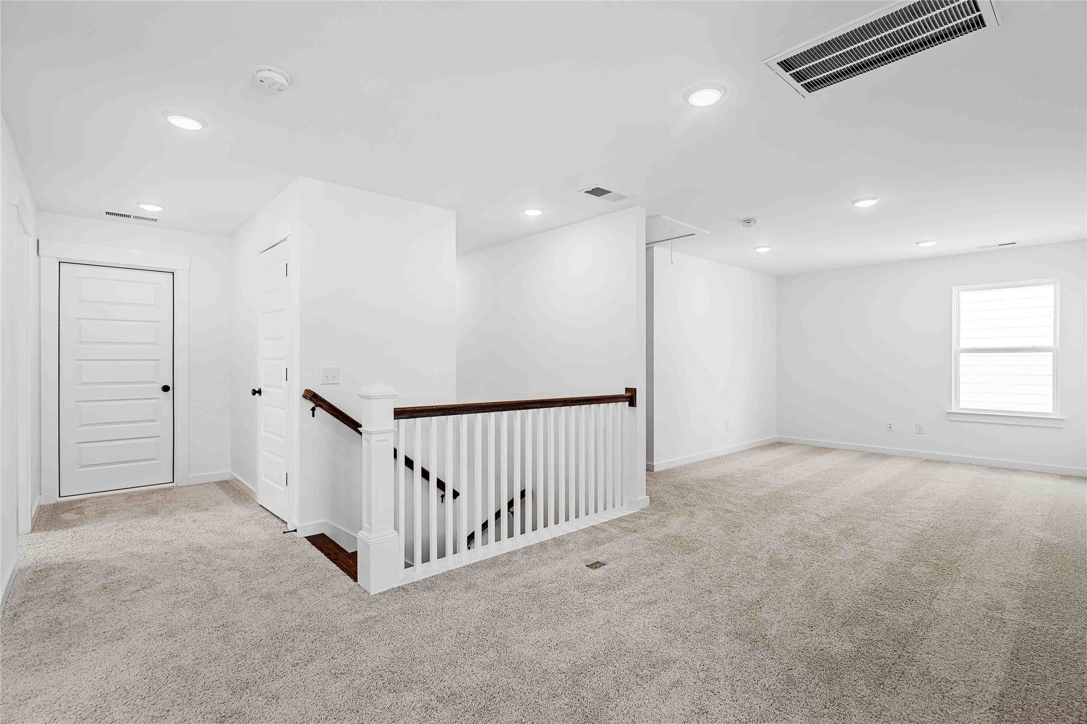 Spacious carpeted game room or loft area overlooking the staircase in a Davidson Homes The Ash O floor plan in Heartland.