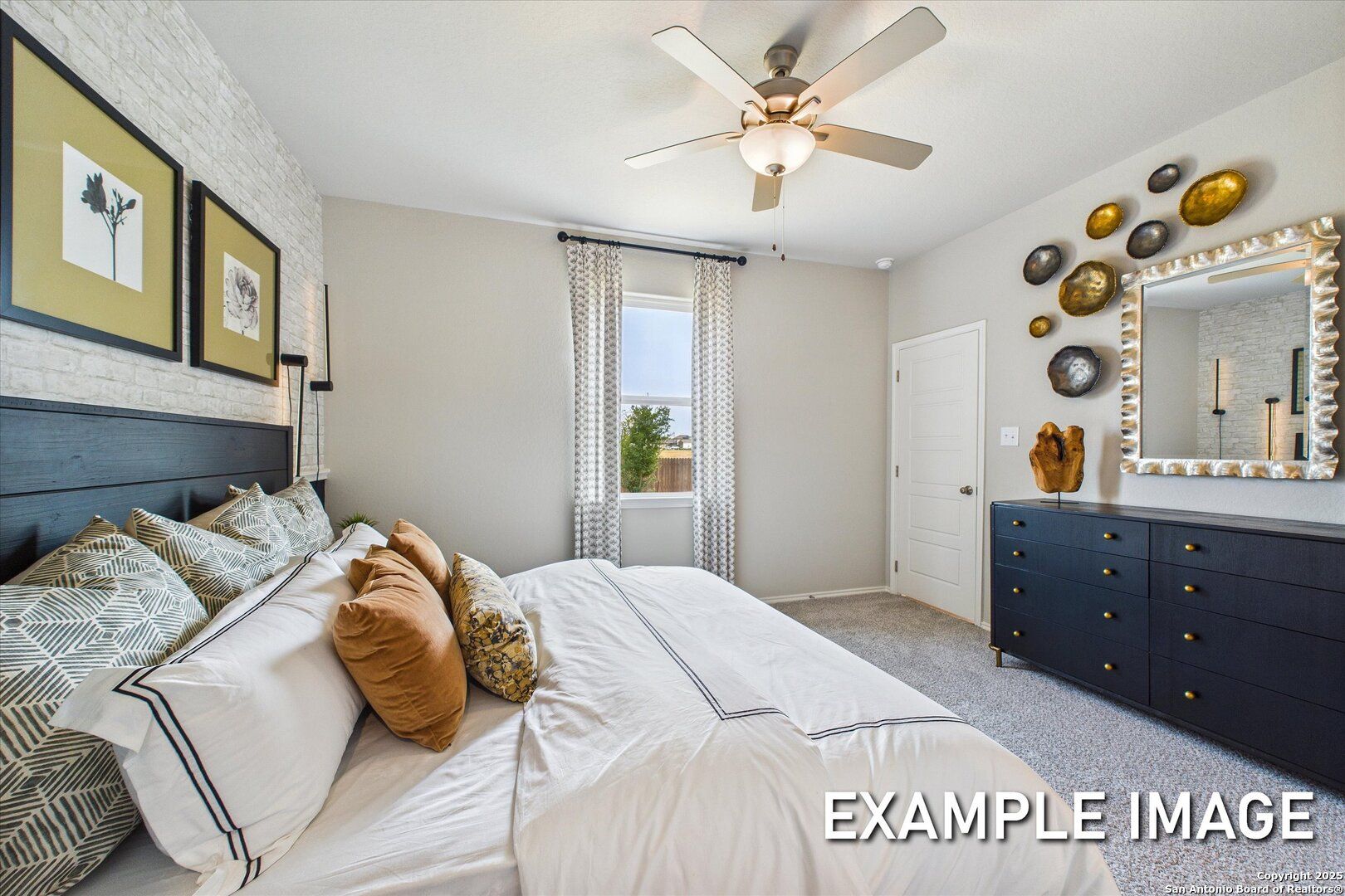 Elegant master bedroom with king bed, black headboard, gold mirror accents, and ceiling fan in Davidson Homes The Sabine C, San Antonio