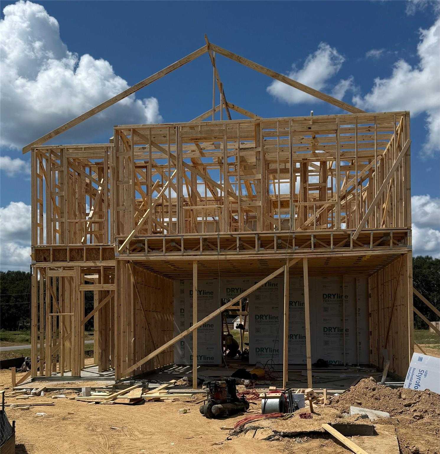 Two-story wooden frame of 5-bedroom Brazos E home under construction by Davidson Homes in Liberty Estates, Cleveland, Texas