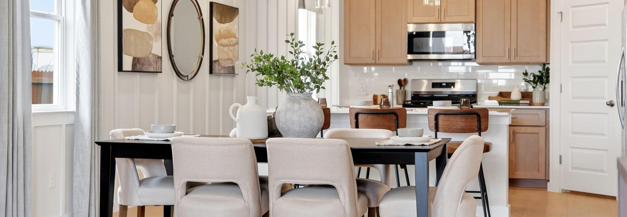 Open-concept dining and kitchen in Heartland Texas Davidson Homes home with light oak cabinets, island stools, and hardwood floors