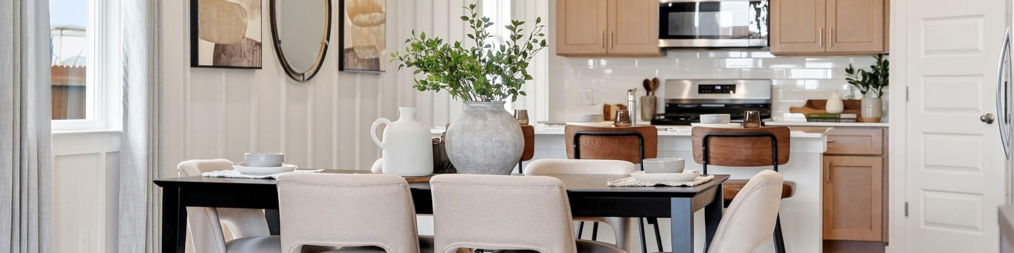 Open-concept dining and kitchen in Heartland Texas Davidson Homes home with light oak cabinets, island stools, and hardwood floors