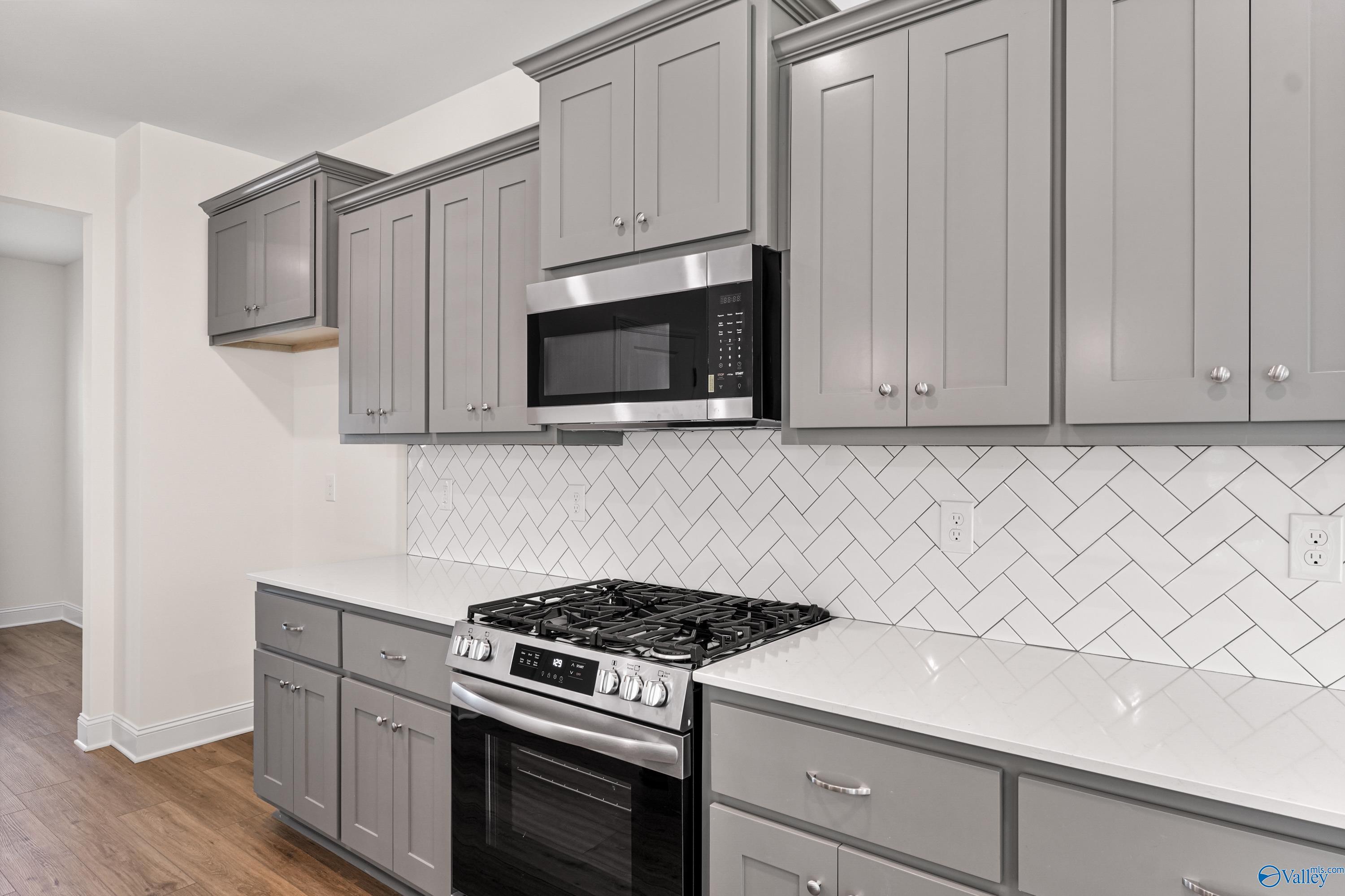 Modern gray shaker kitchen with white subway tile backsplash, stainless gas range in Davidson Homes The Shelby A, Athens AL