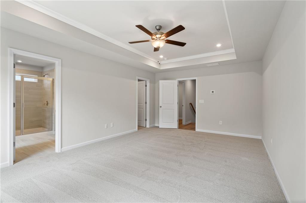 Spacious master bedroom with tray ceiling, ceiling fan, and en-suite shower in Davidson Homes The Marion B, Kennesaw, GA