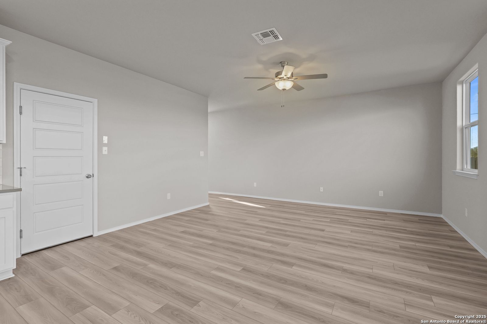 Bright secondary bedroom with ceiling fan, hardwood floors, and attached bath in Davidson Homes The Trinity D, San Antonio