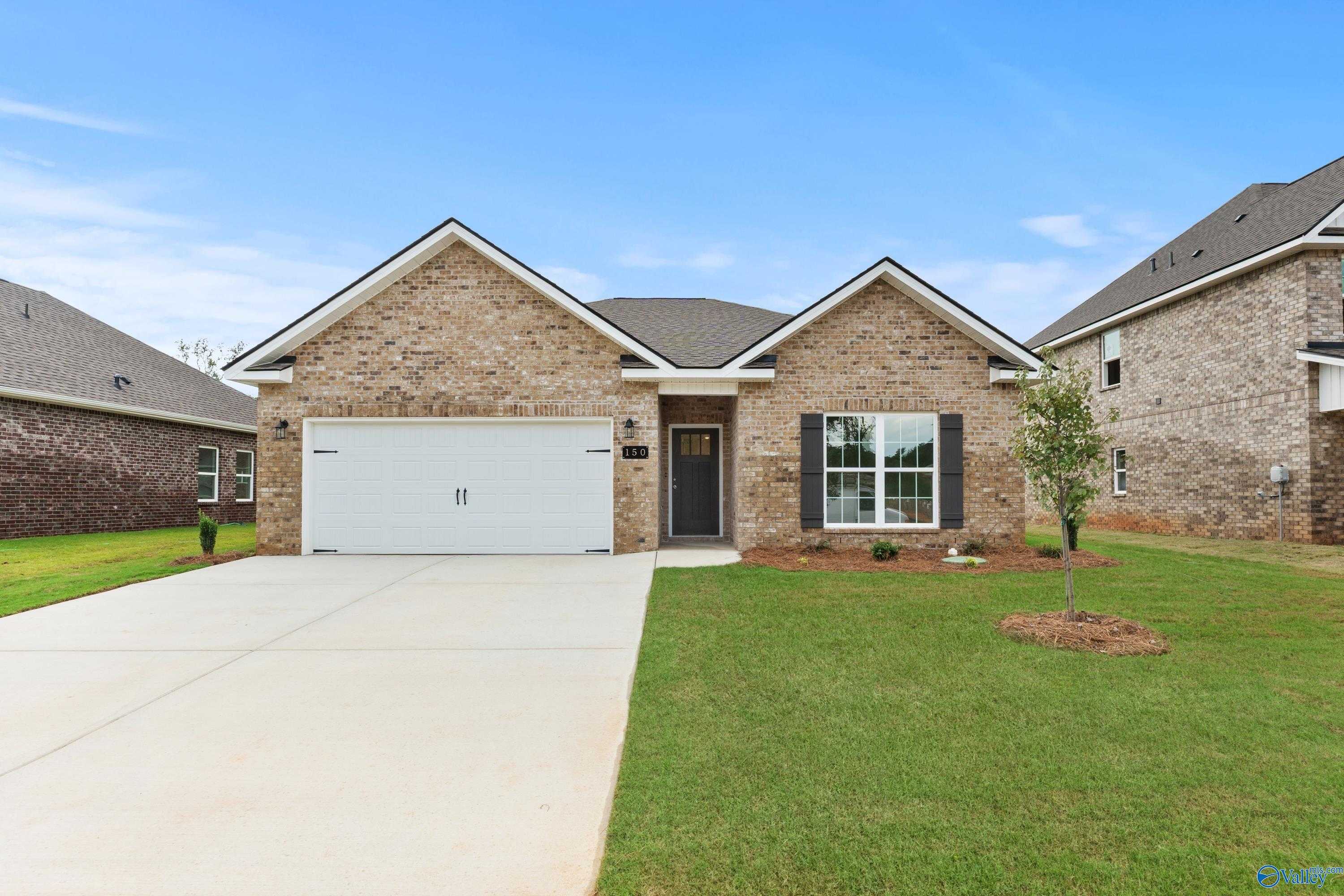 Brick 1-story home with 2-car garage, driveway, and lush front yard in Creek Grove, New Market, Alabama
