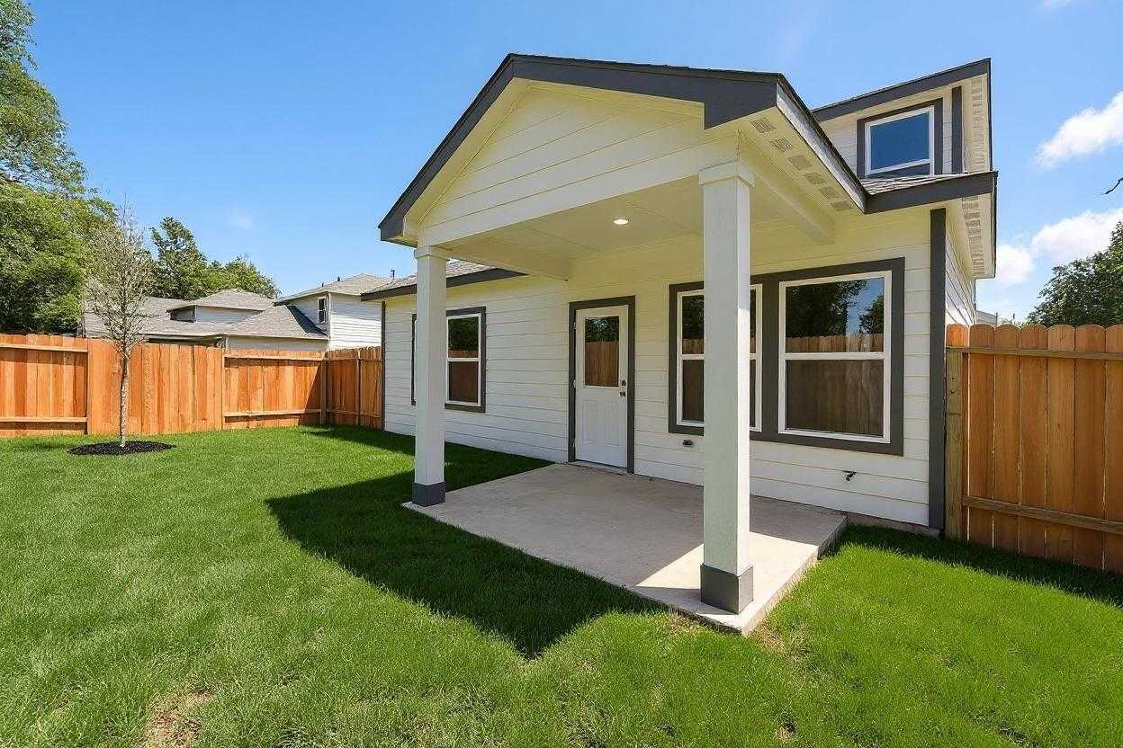 Modern two-story home exterior with covered porch, white siding, and fenced backyard in Conroe, Texas Davidson Homes Sabine E