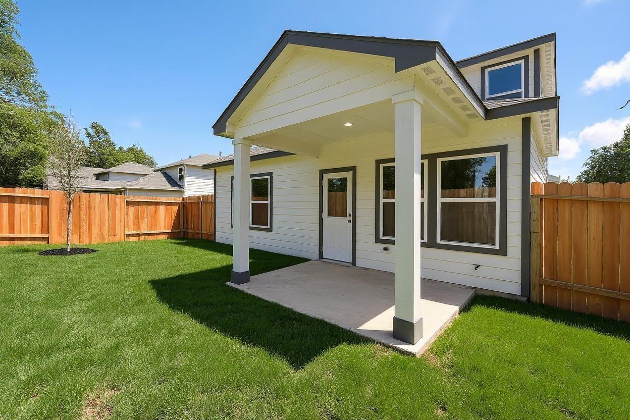 Modern two-story home exterior with covered porch, white siding, and fenced backyard in Conroe, Texas Davidson Homes Sabine E