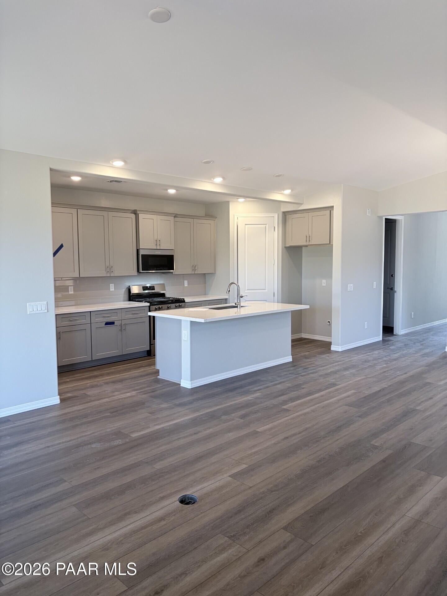 Modern open-concept kitchen with gray cabinets and island in The Frontier A floor plan at North Ridge, Prescott Valley.