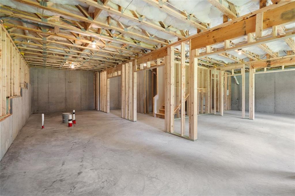 Unfinished basement featuring wooden framing, ceiling insulation, and concrete floors in The Willow B home by Davidson Homes, Hoschton, GA
