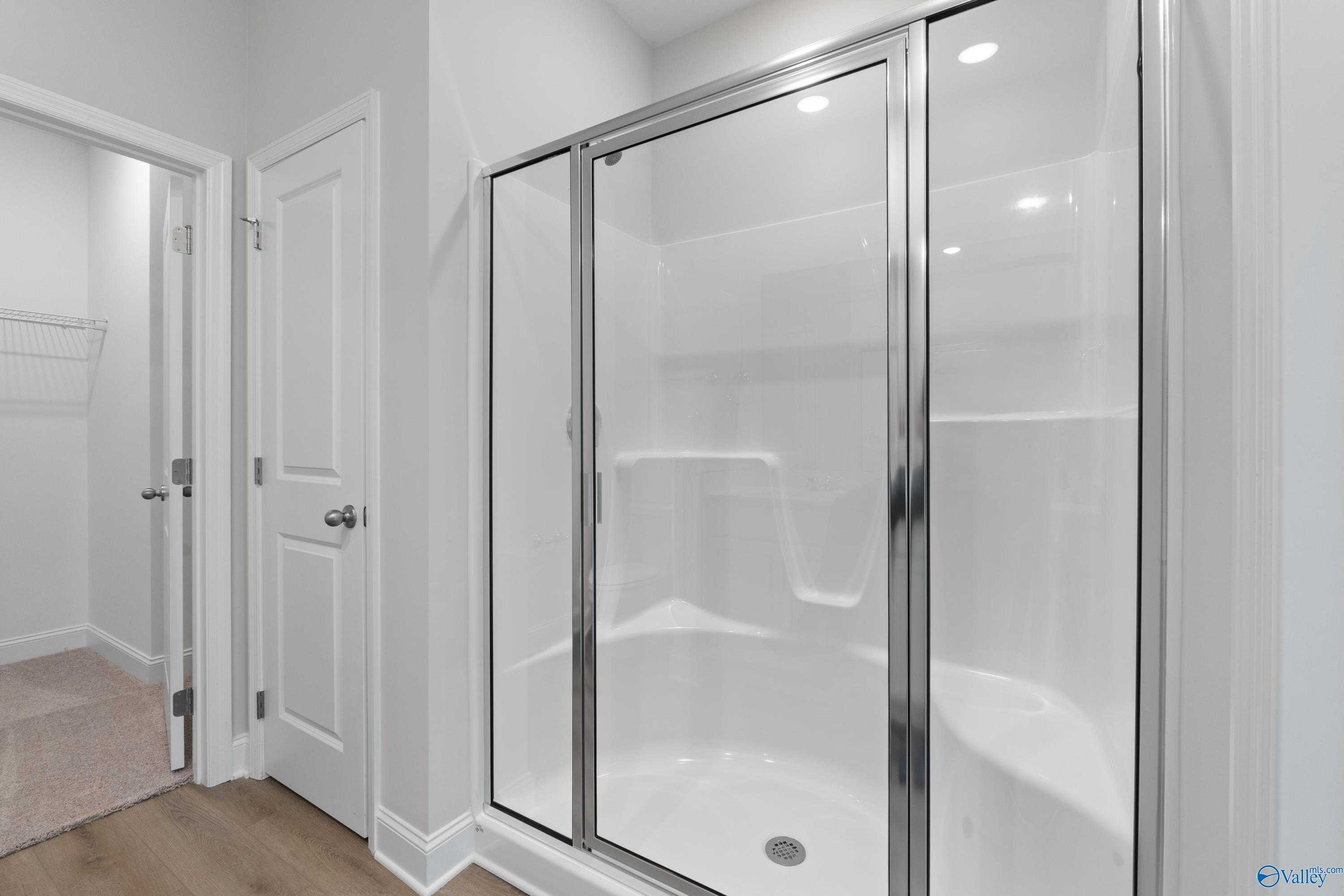 Modern frameless glass shower with white subway tiles in master bathroom of Davidson Homes The Asheville C, Huntsville, AL