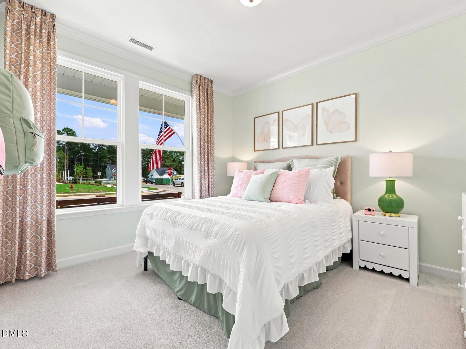 Cozy guest bedroom with ruffled bedding and green accents in The Daphne C floor plan at Woodland Crossing, Zebulon, NC.