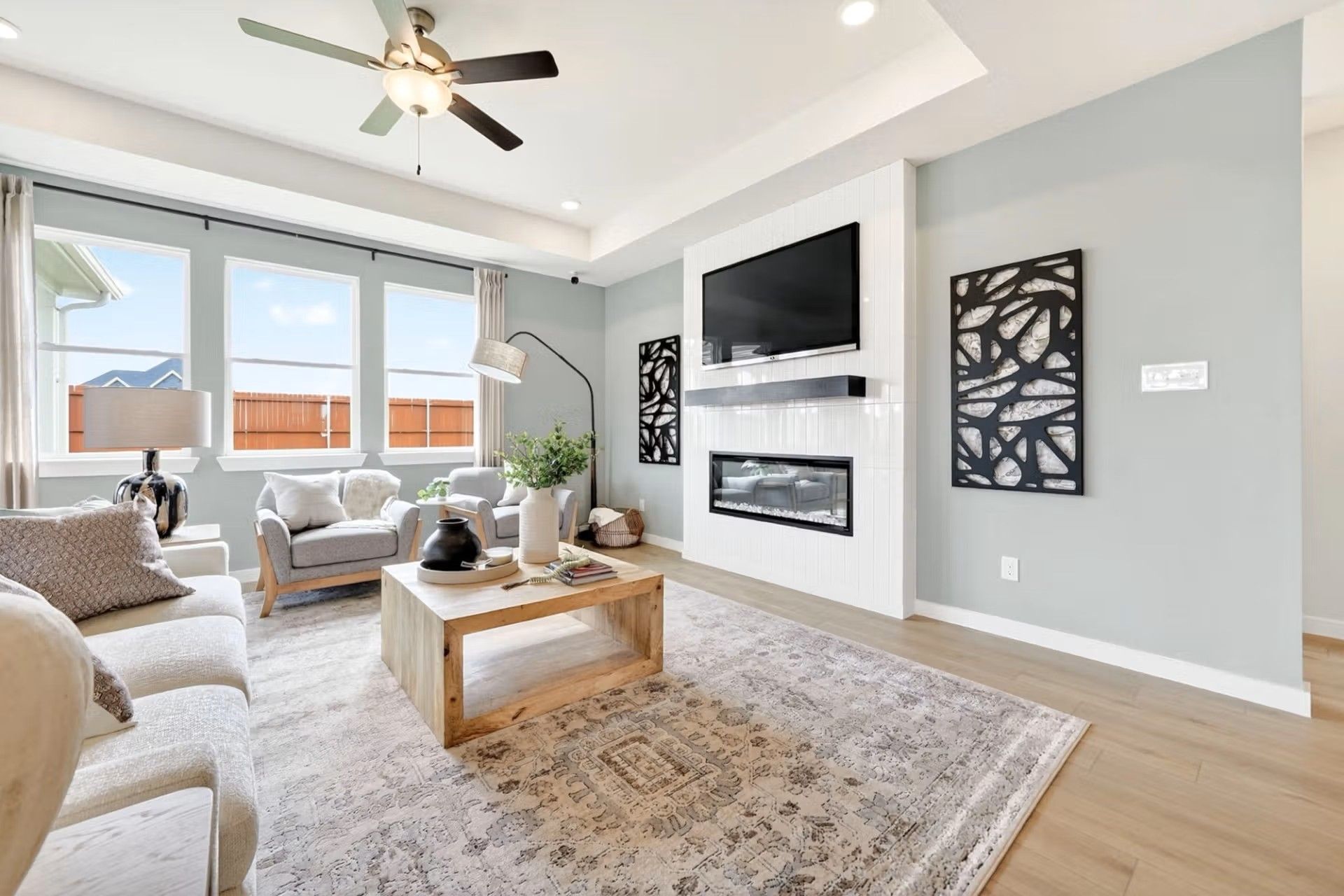 Modern living room with tray ceiling, fireplace, and flat-screen TV in The Laurel I floor plan by Davidson Homes, Heartland.