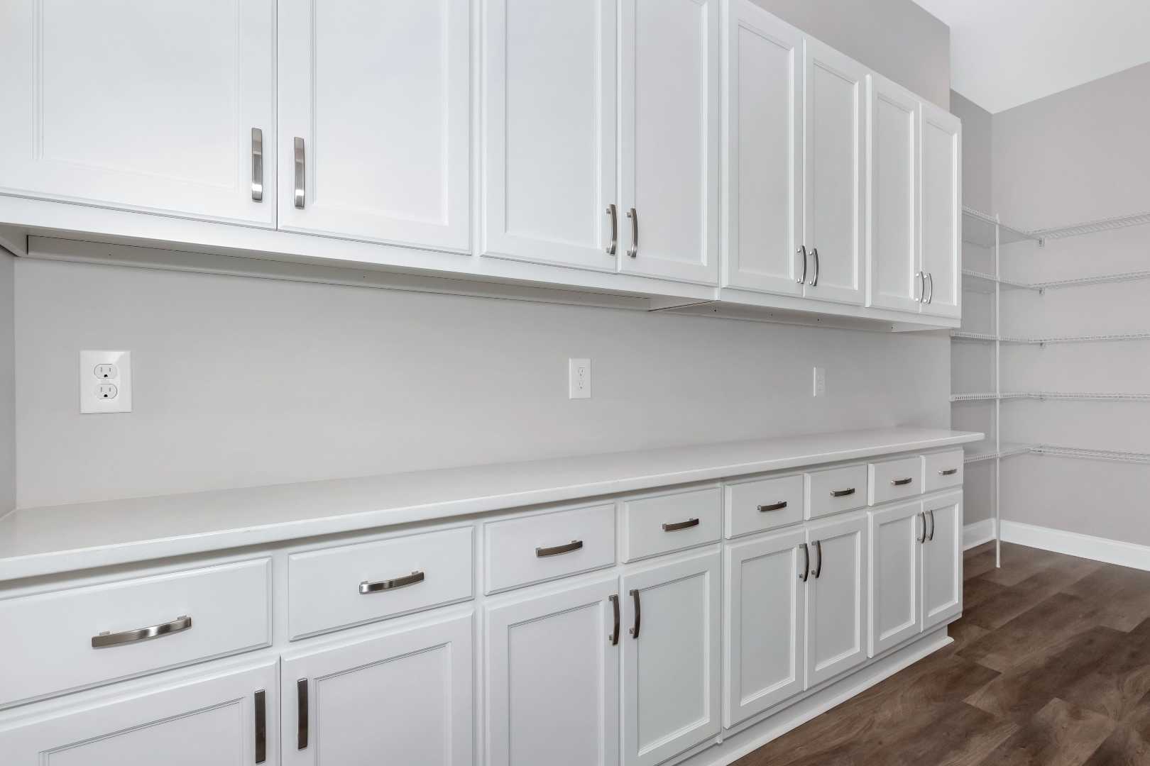 Spacious walk-in pantry in The Arcadia M featuring white shaker cabinets, quartz countertop, and open wire shelving
