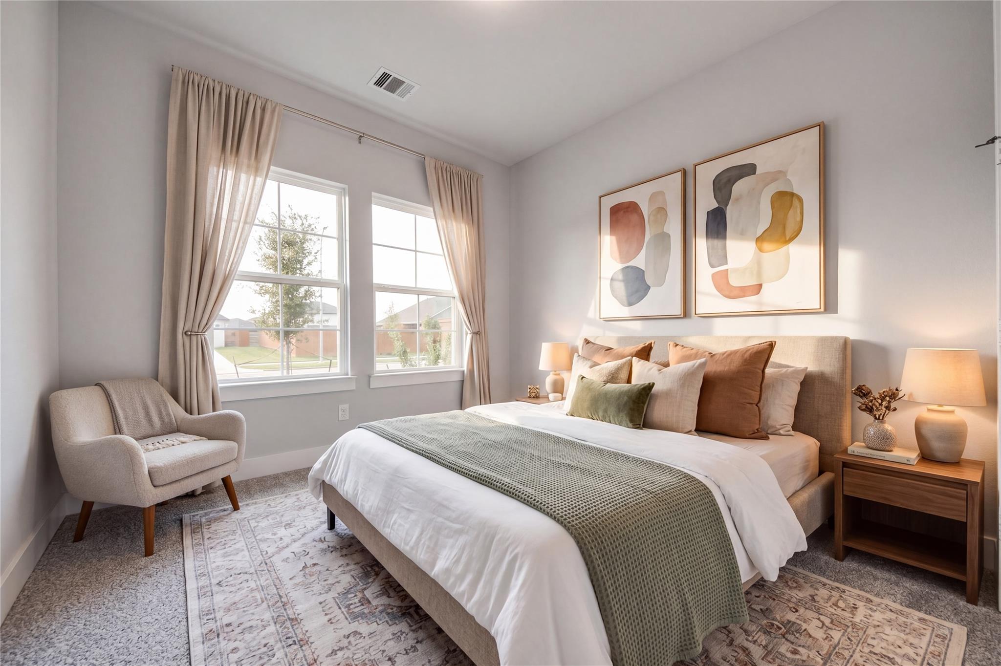 Bright primary bedroom with neutral bedding, accent chair, and large windows in Davidson Homes The Laguna C, Sunterra, Katy, Texas