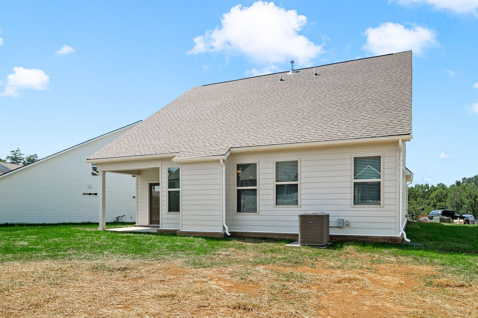 Rear exterior of The Ash A floor plan by Davidson Homes featuring a covered patio in Woods Crossing, Gallatin, Tennessee.
