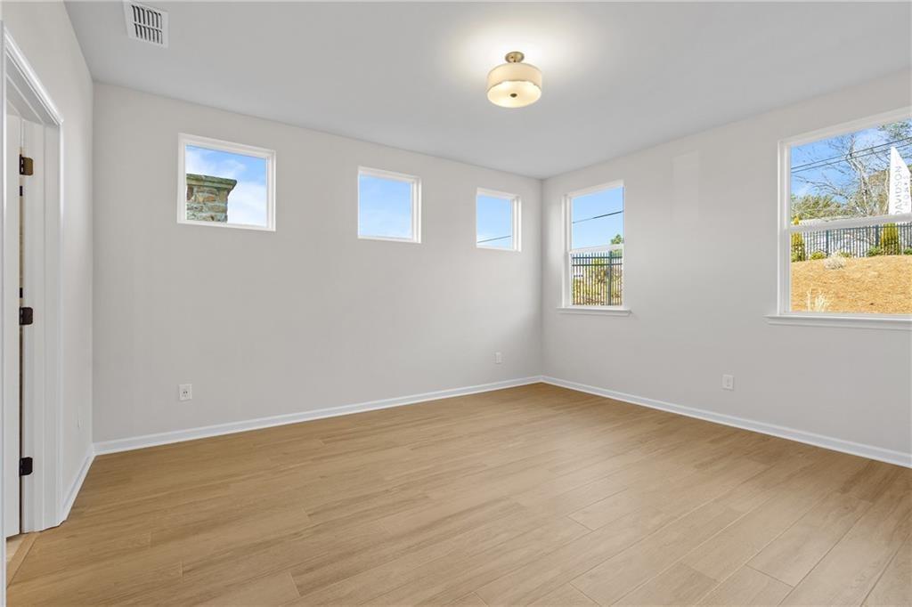 Bright living room with hardwood floors, large windows, and natural light in Davidson Homes The Edison B, Kelly Preserve