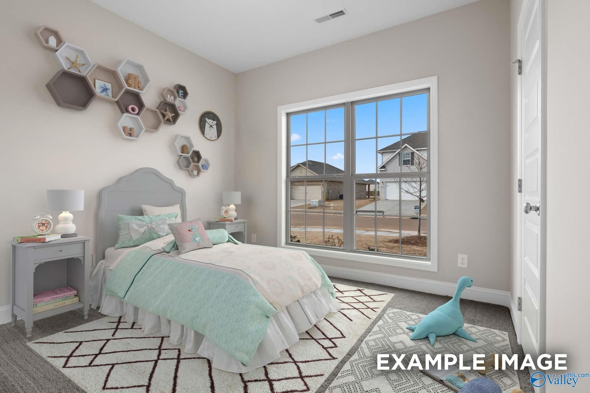 Cozy girl's bedroom with mint green bedding, hexagon wall shelves, and neighborhood view through large window in Davidson Homes The Everett, Meridianville, Alabama