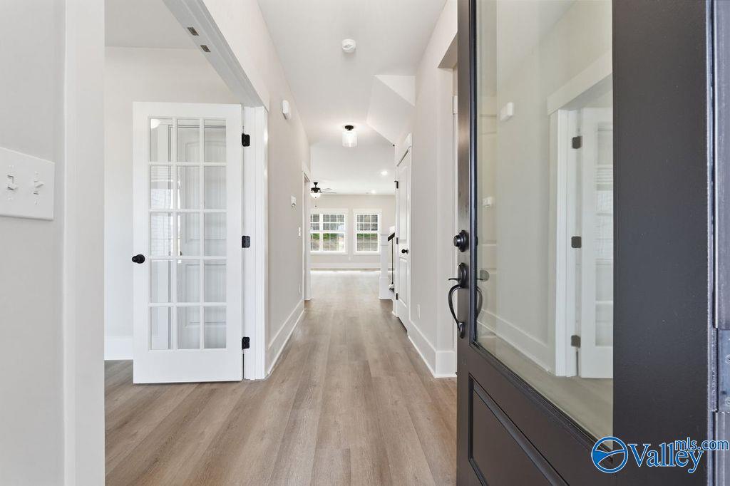 Elegant entry hallway with glass-paneled doors, hardwood floors, and open layout in Davidson Homes The Rockford, Hartselle, Alabama