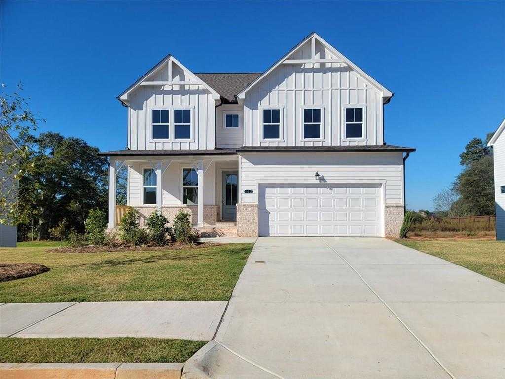 Modern white board-and-batten 4-bedroom home with gabled roof, 2-car garage, and front porch in Wehunt Meadows, Hoschton, Georgia