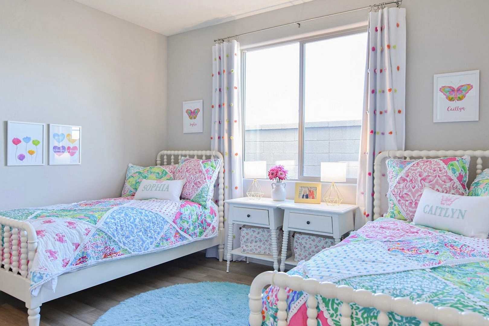 Cozy girls' shared bedroom at North Ridge Pronghorn Ranch in Prescott Valley AZ with twin beds, colorful quilts and butterfly decor