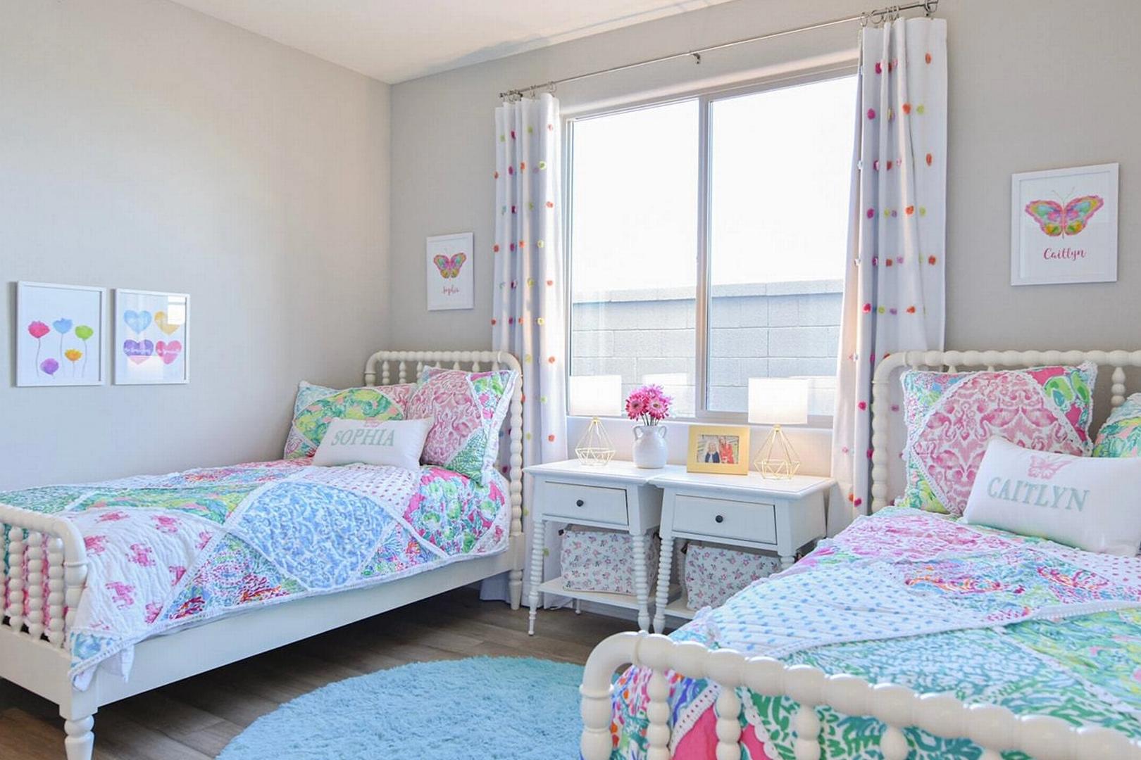Cozy girls' shared bedroom at North Ridge Pronghorn Ranch in Prescott Valley AZ with twin beds, colorful quilts and butterfly decor