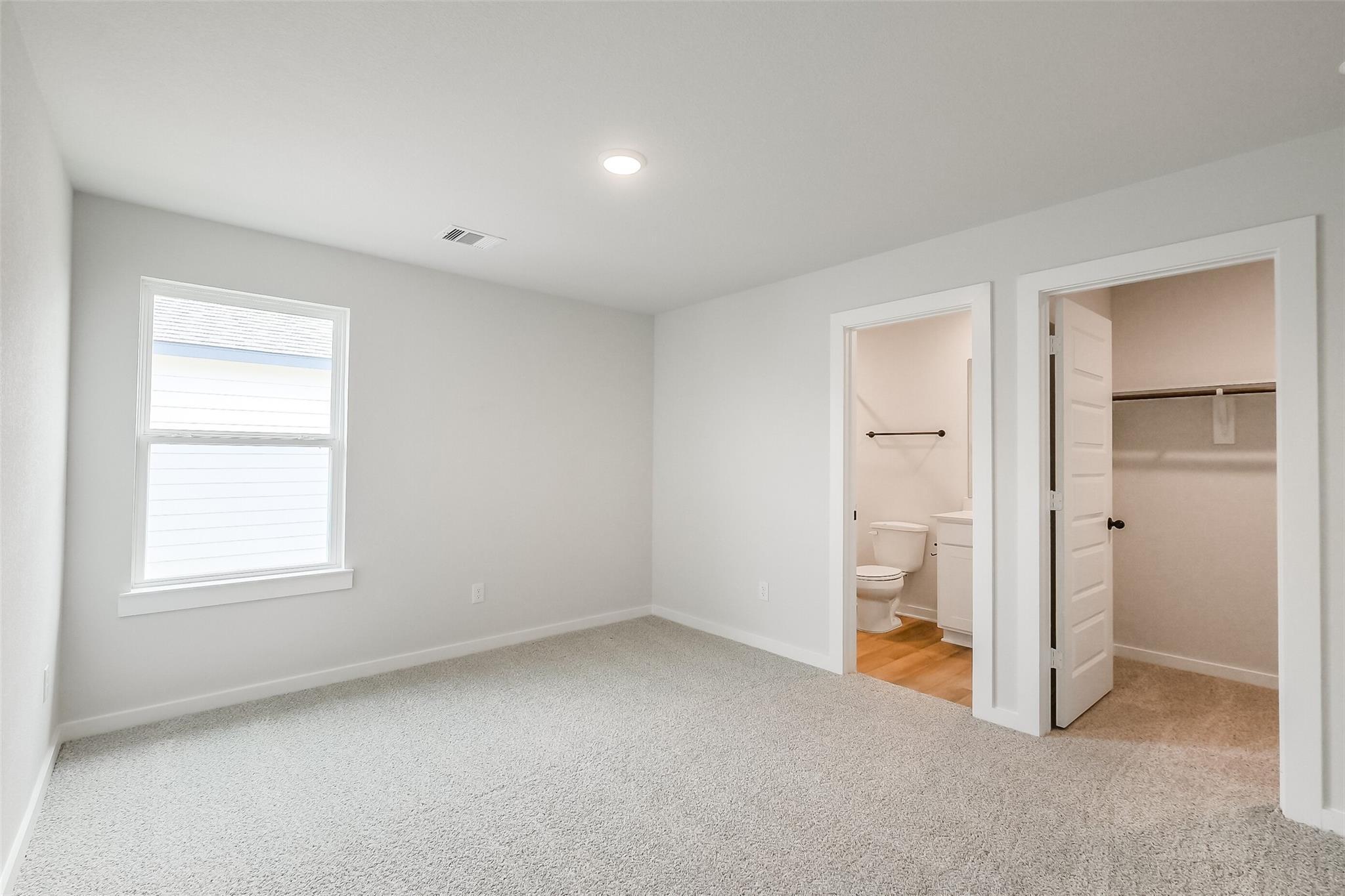 Bright secondary bedroom with en-suite bathroom and walk-in closet in Davidson Homes Tierra B, Emberly, Beasley, Texas
