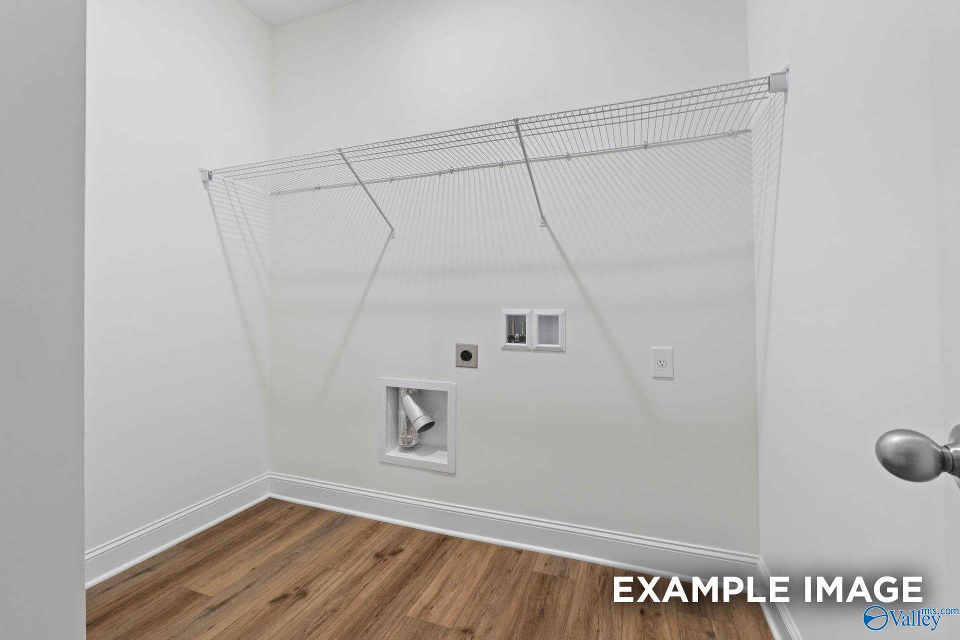 Spacious laundry closet with washer/dryer hookups, wire shelving, and outlets in Davidson Homes The Daphne D, Athens, Alabama