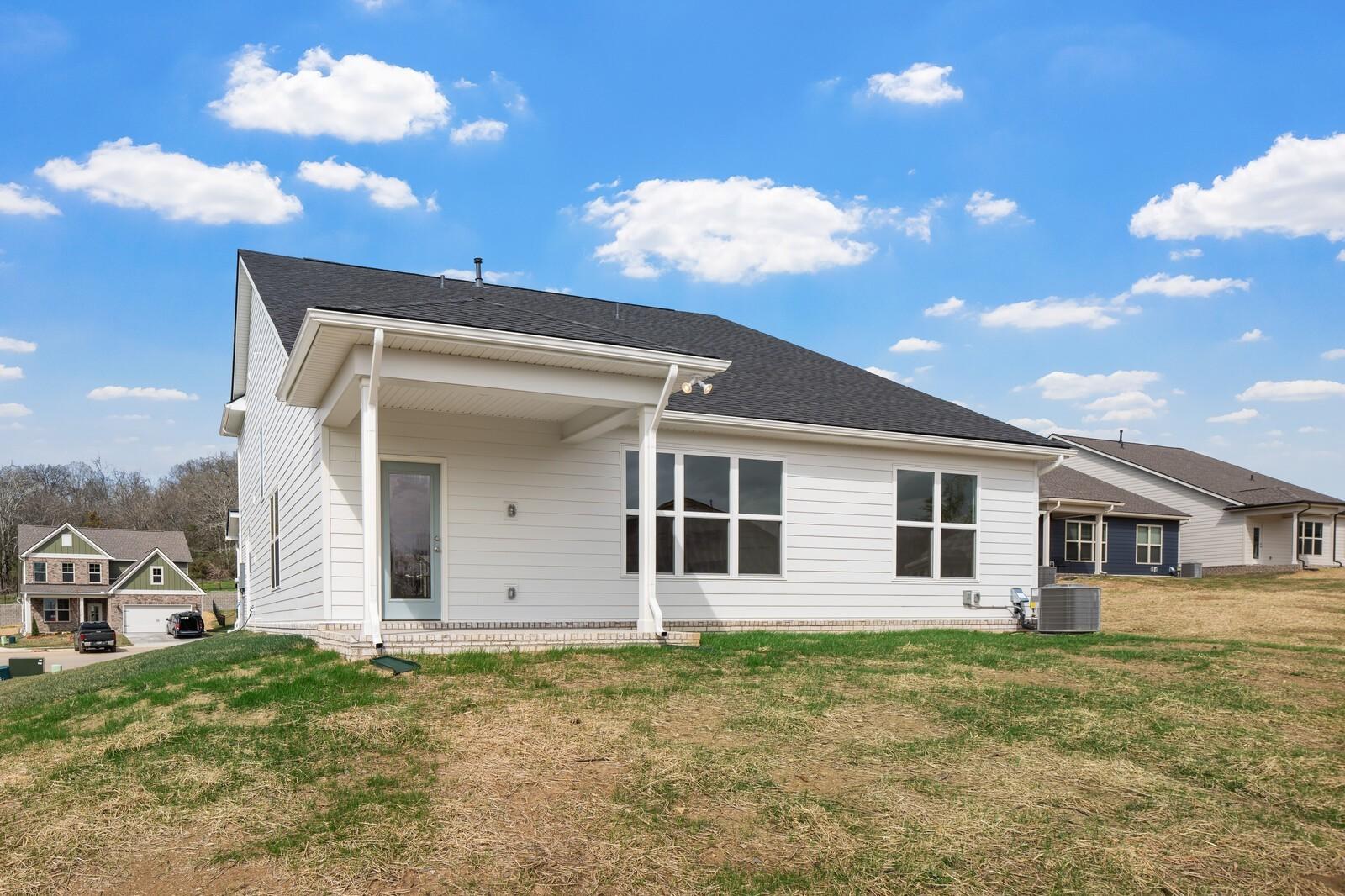 Modern two-story white home with covered front porch, large windows, and side garage in Woods Crossing, Gallatin, Tennessee - Davidson Homes The Ridgeport