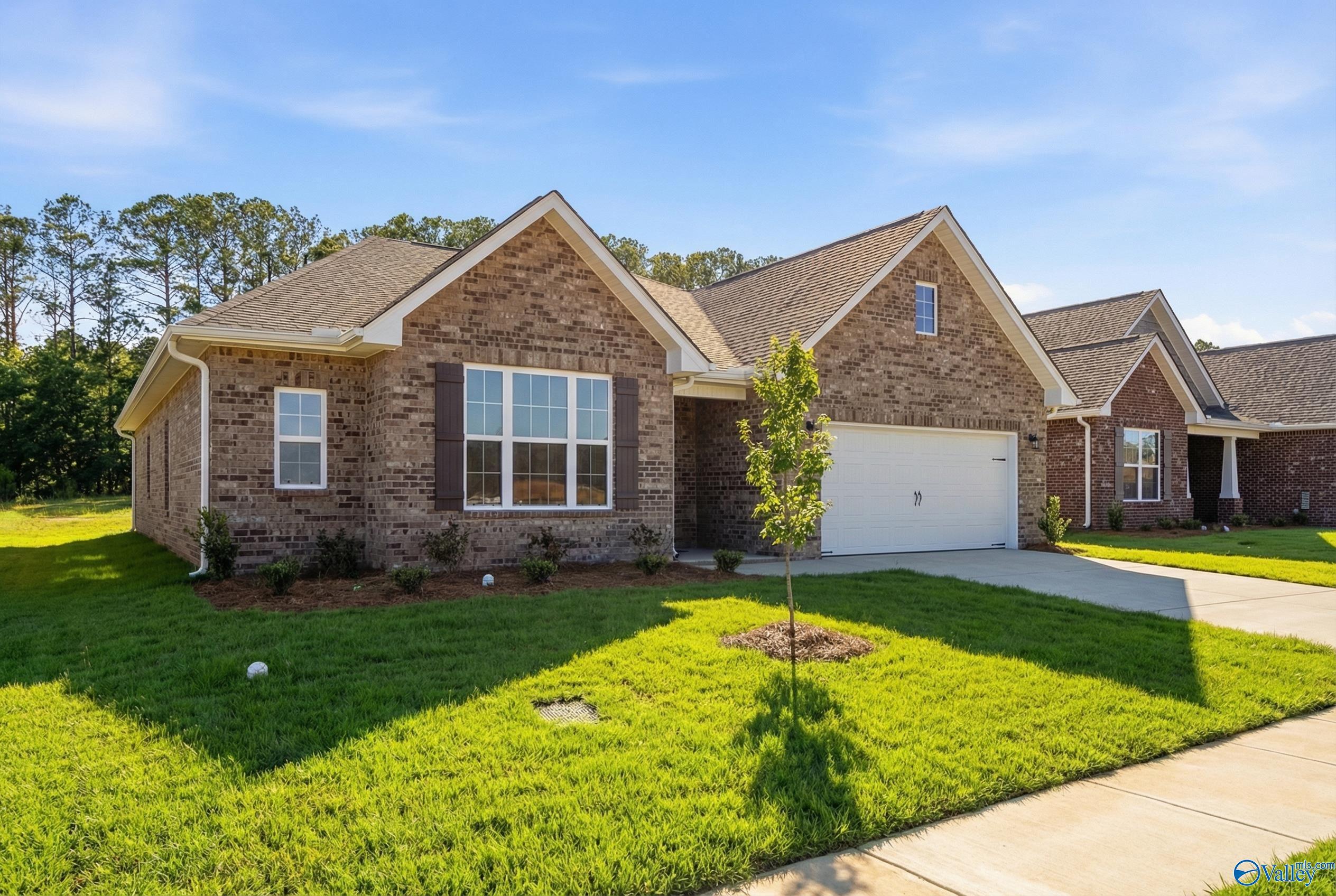 Brick ranch-style home with 2-car garage, shutters, and landscaped yard in Cain Park, Hartselle, Alabama by Davidson Homes