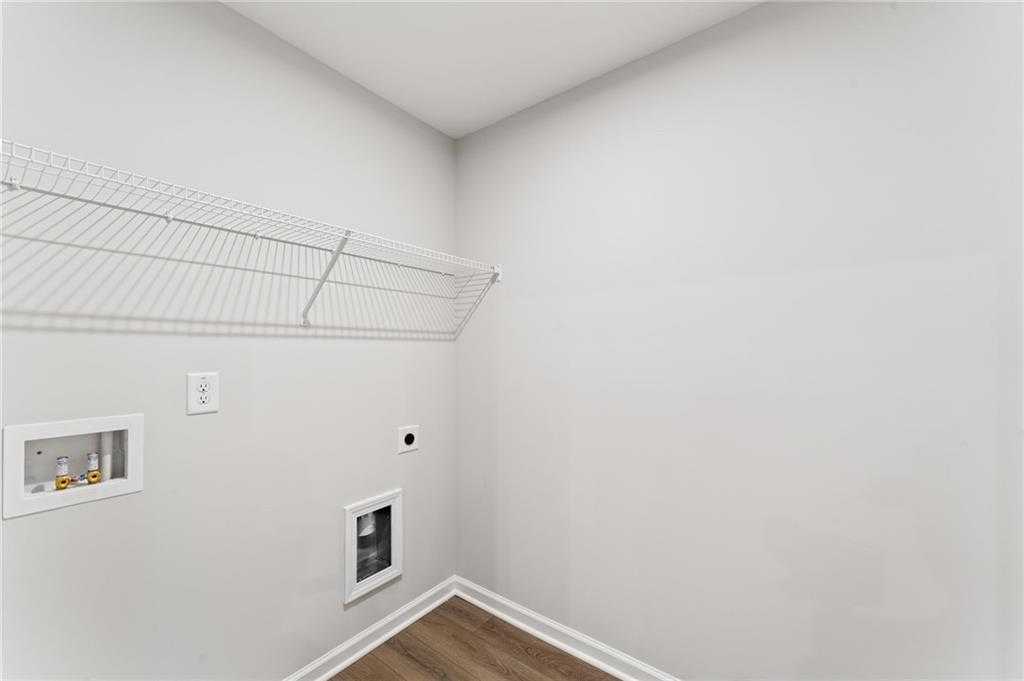 Functional laundry room featuring wire shelving, utility sink, and dryer vent in Davidson Homes The Monroe A, Emerson, Georgia