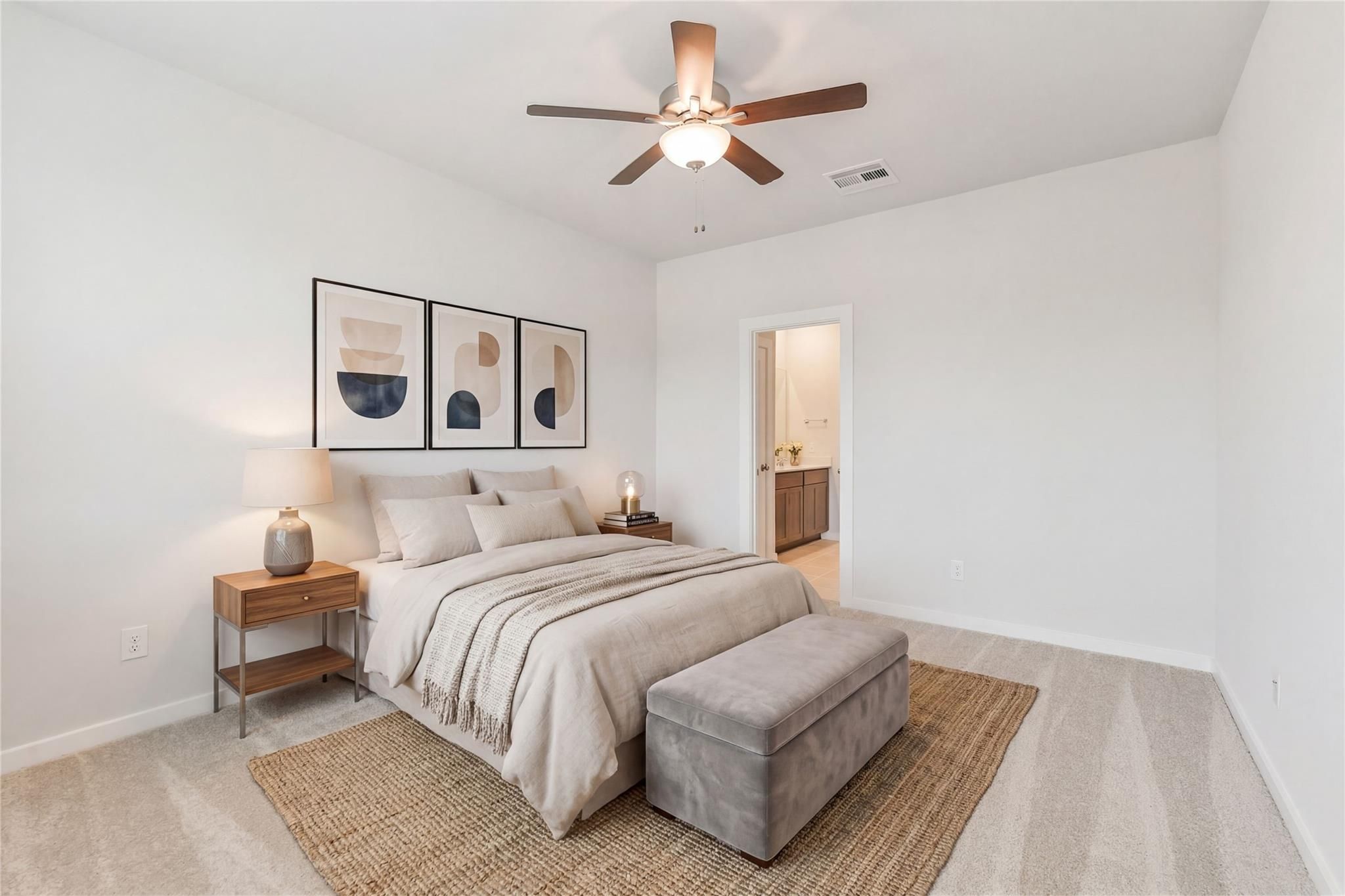 Cozy secondary bedroom with ceiling fan, abstract art, plush bed, bench, and rug in Davidson Homes The Brazos E, Cleveland, Texas