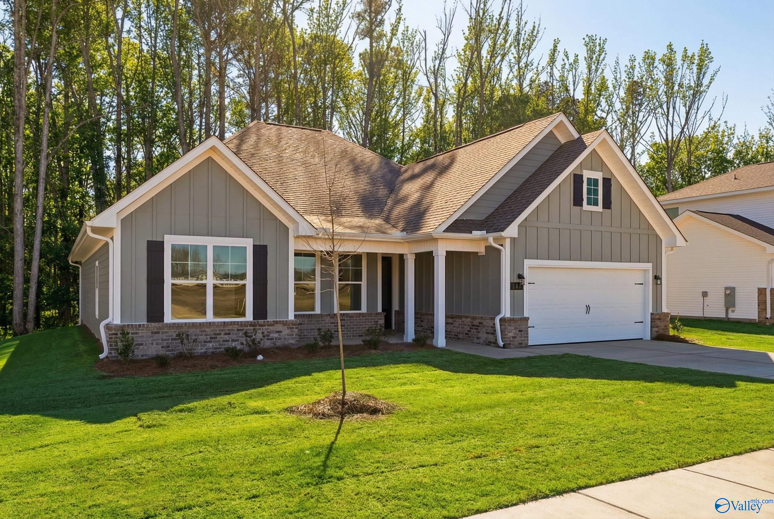 Modern gray 1-story home with 2-car garage, white trim, and lush green yard in Forest Glen, Hazel Green, Alabama - Davidson Homes Rockford D