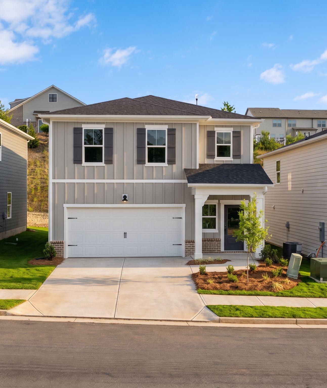 New construction homes by Davidson Homes at The Bluffs in Canton, Georgia featuring modern siding and two-car garages.