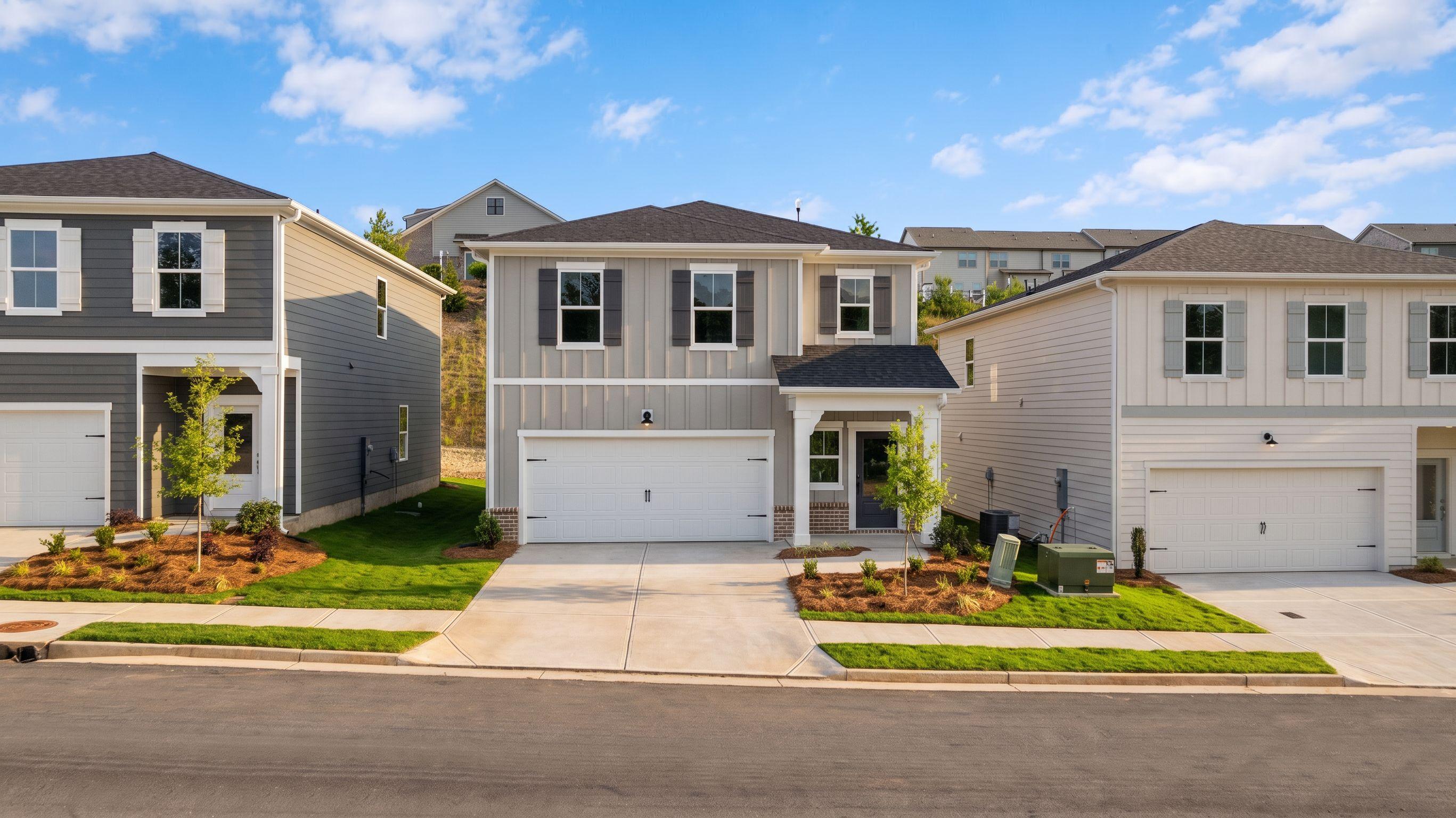 New construction homes by Davidson Homes at The Bluffs in Canton, Georgia featuring modern siding and two-car garages.