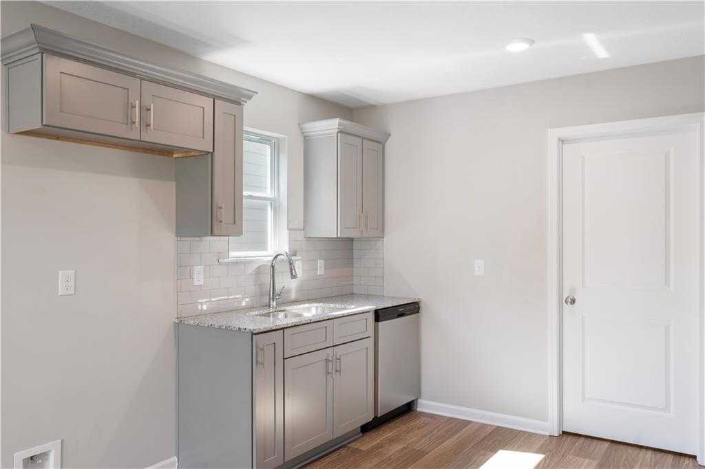 Modern kitchen with gray shaker cabinets, white subway tile backsplash, stainless dishwasher in Davidson Homes The Washington, Phenix City