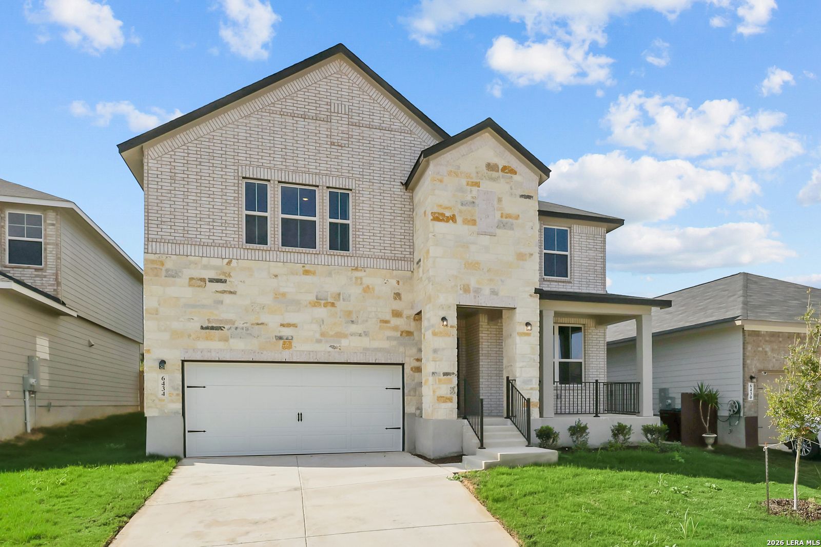 Two-story brick and stone exterior with covered porch and 2-car garage in Davidson Homes' The Sequoia C at Royal Crest, San Antonio.