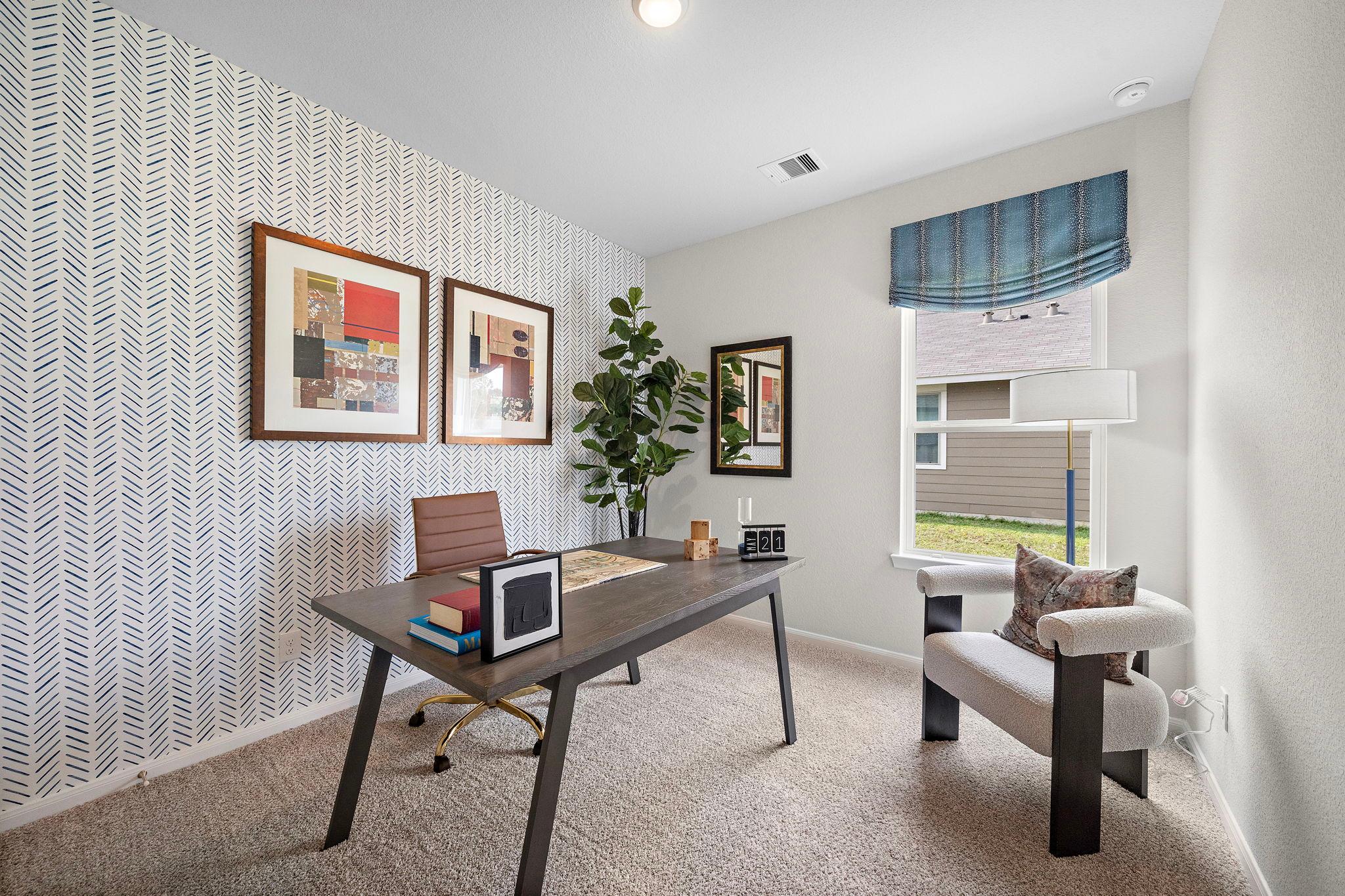 Modern home office in Liberty Estates, Cleveland Texas with blue patterned walls, wooden desk, leather chair, fiddle leaf fig and artwork