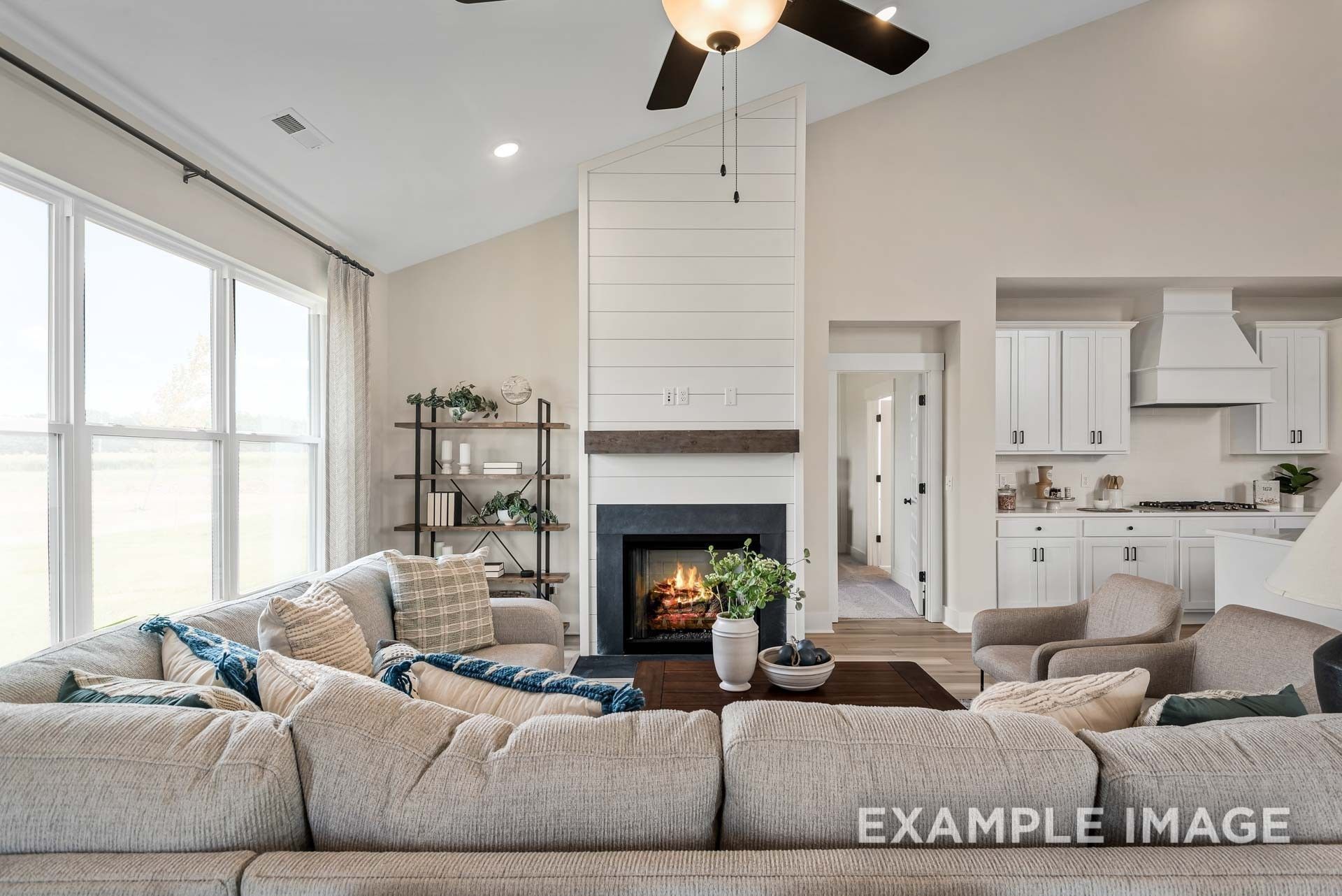 Cozy living room with shiplap fireplace, sectional sofa and vaulted ceiling in The Ridgeport 4-bedroom home, Gallatin, TN