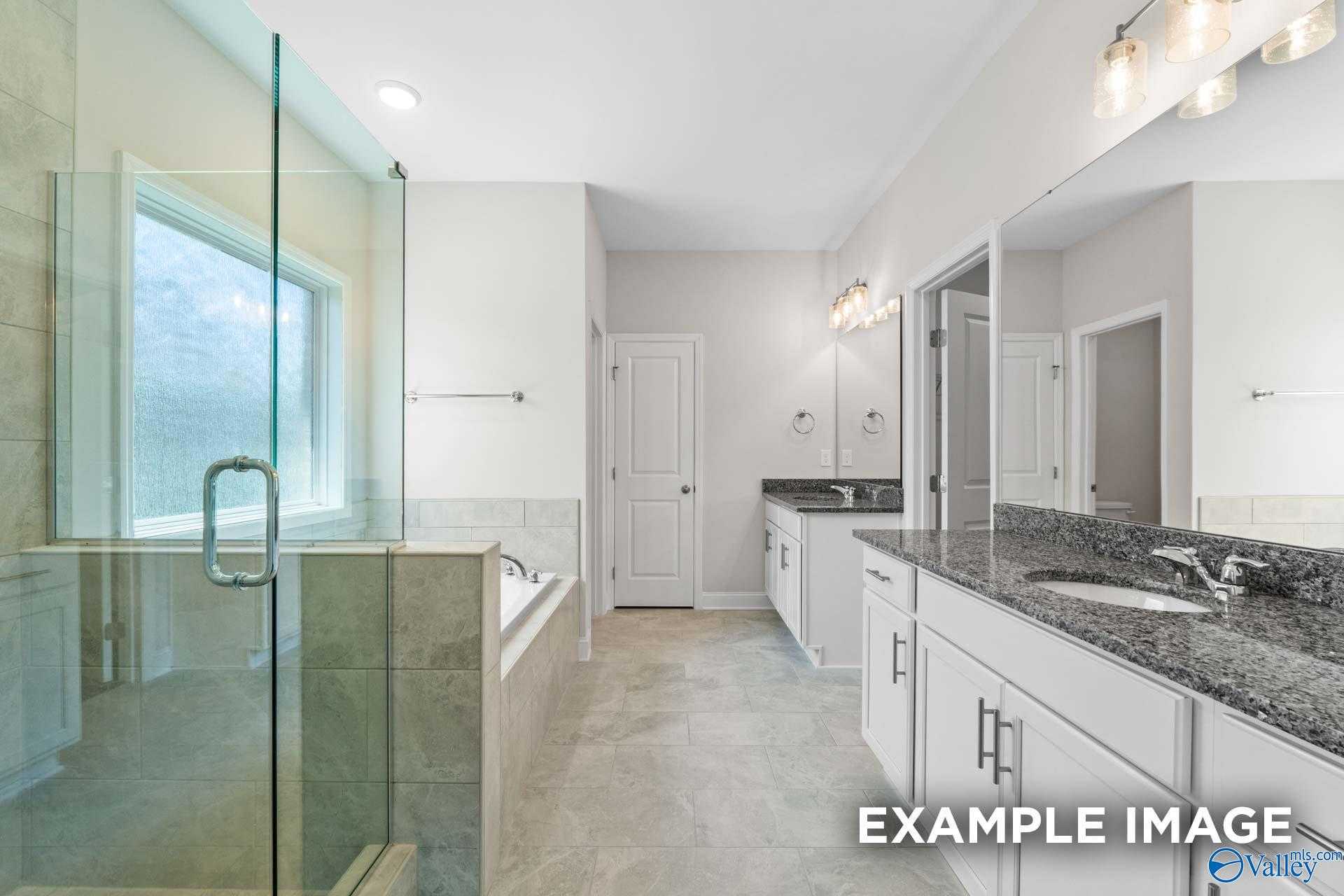 Luxurious master bathroom with frameless glass shower, soaking tub, granite double vanity in Davidson Homes The Lanier, Meridianville AL