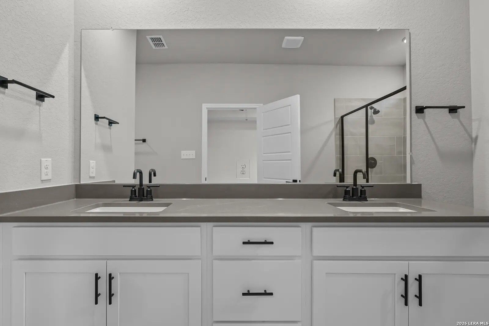 Modern double vanity with white cabinets and matte black fixtures in The Glenwood E floor plan, Comanche Ridge, San Antonio.