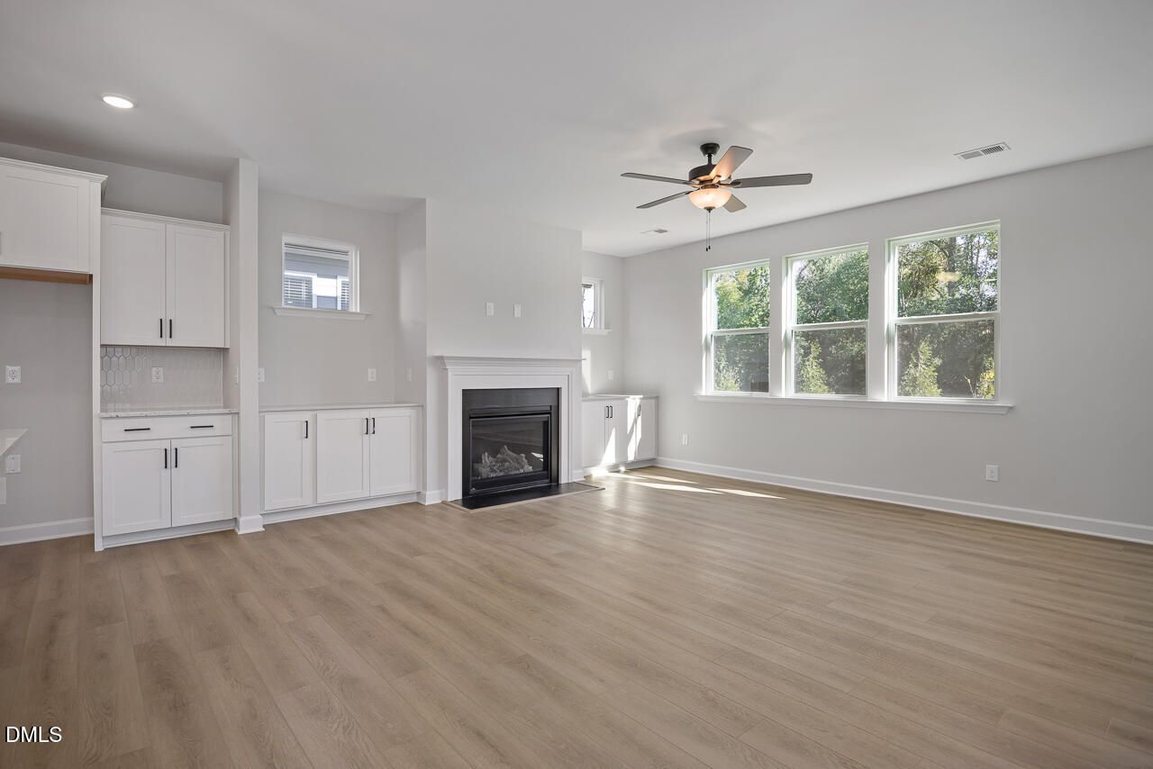 Bright open-concept great room with fireplace, white built-ins, and hardwood floors in Davidson Homes The Preston C, Wendell Ridge NC