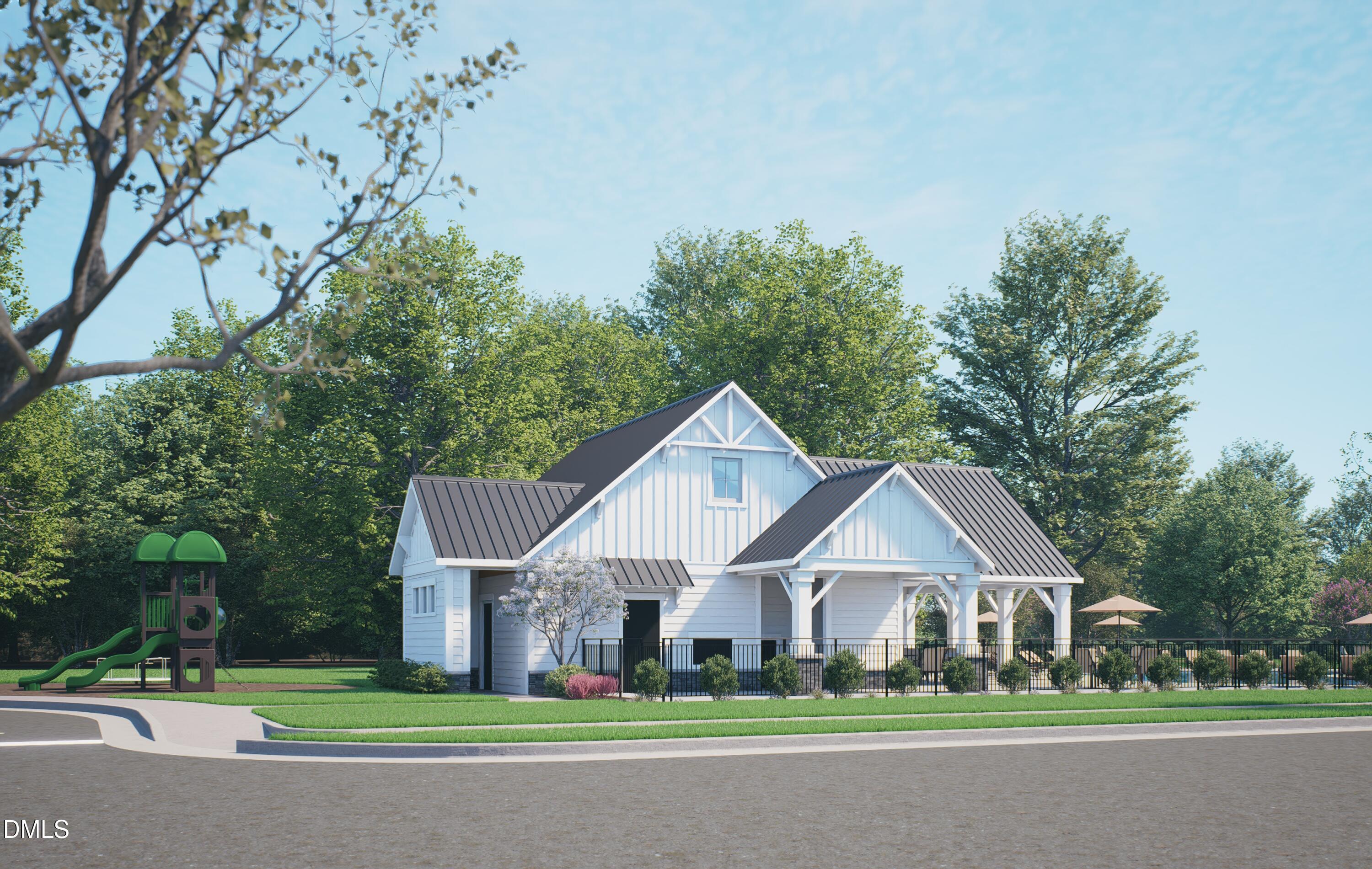 White farmhouse-style 3-bedroom townhome exterior with gabled metal roof, 2-car garage, playground, and gazebo in Knightdale, NC