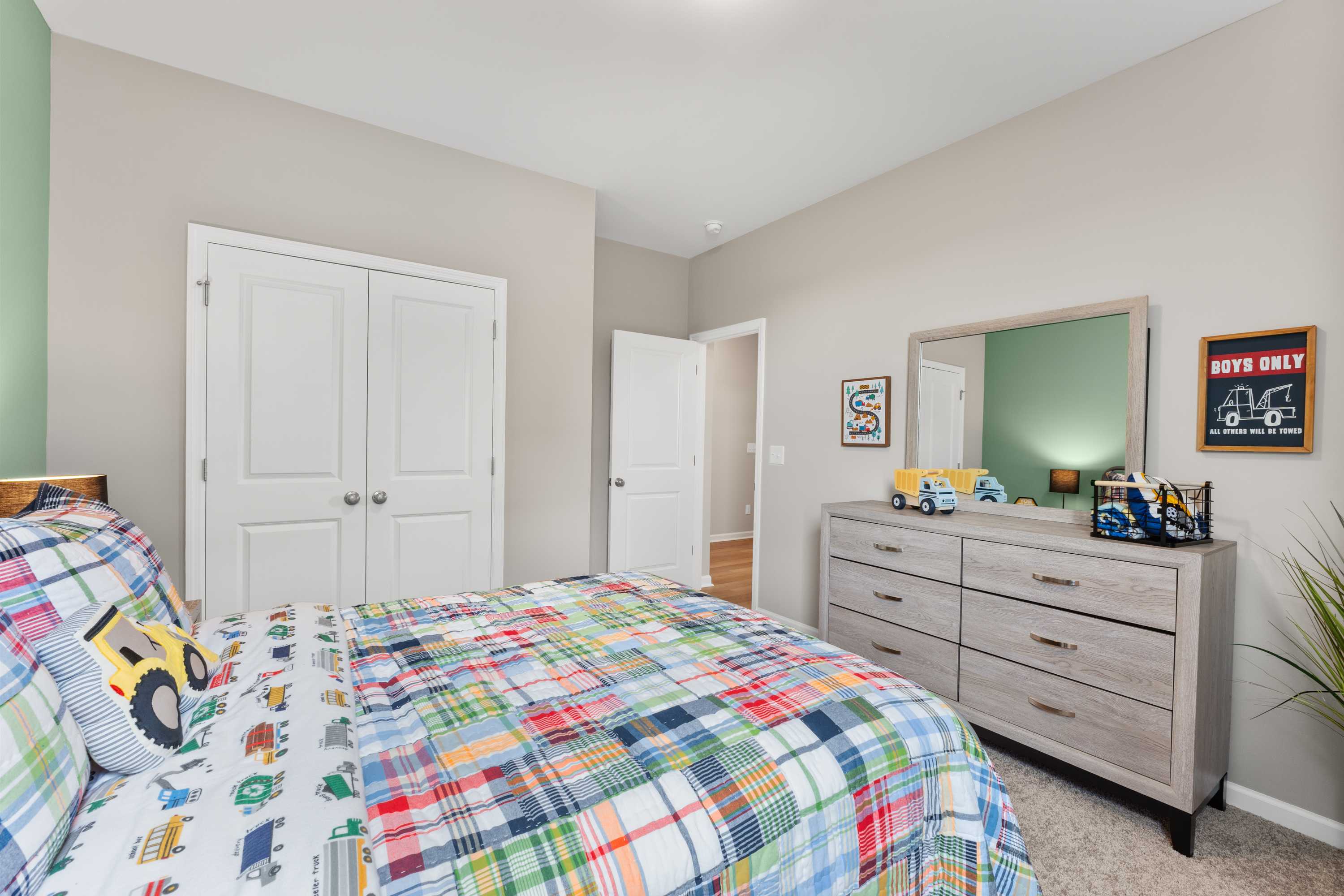 Boy's bedroom at Anderson Farm in Athens Alabama with construction truck bedding, light wood dresser, and mirror