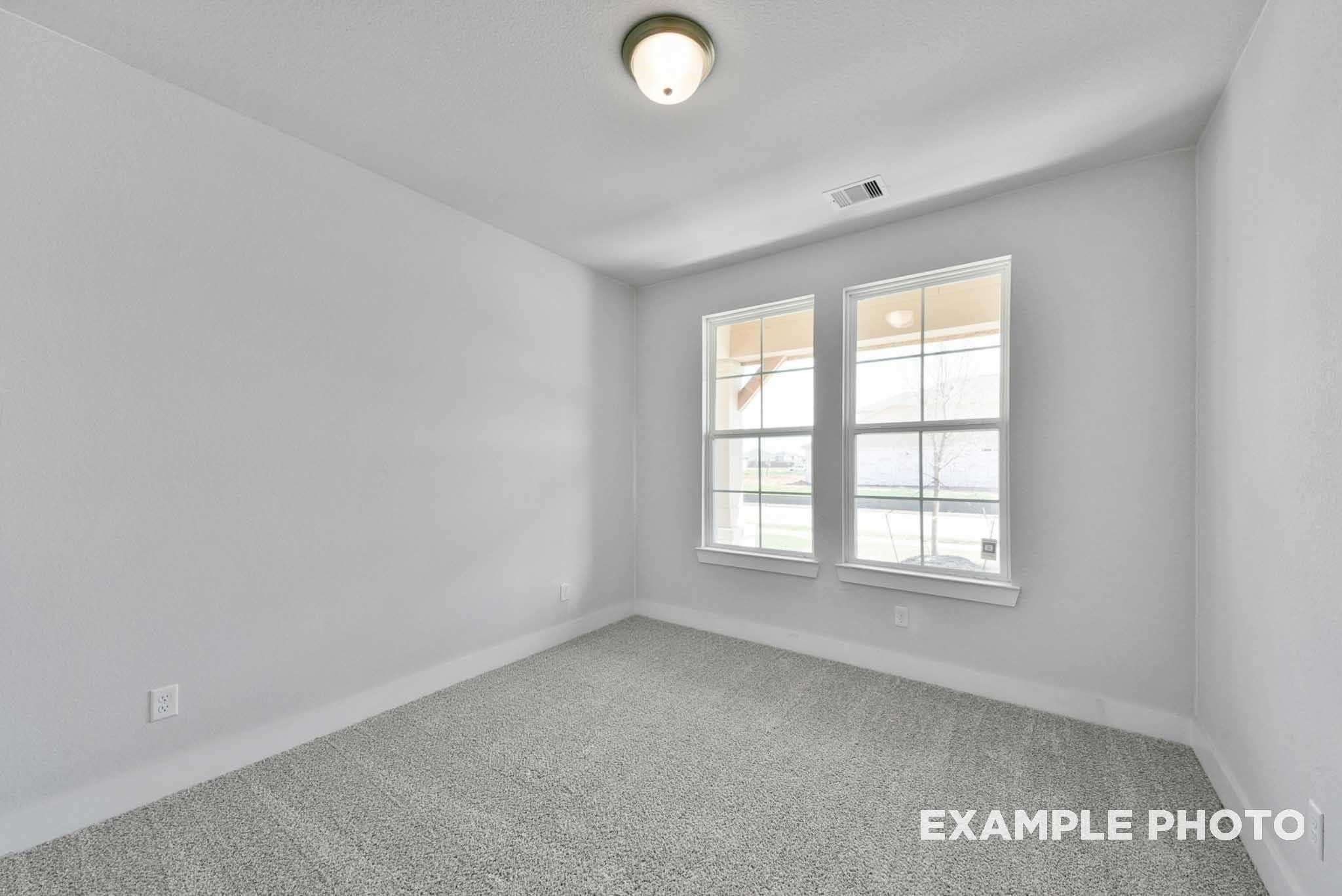 Bright secondary bedroom featuring gray carpet, white walls, and double windows in Davidson Homes The George A, Lago Mar, Texas City