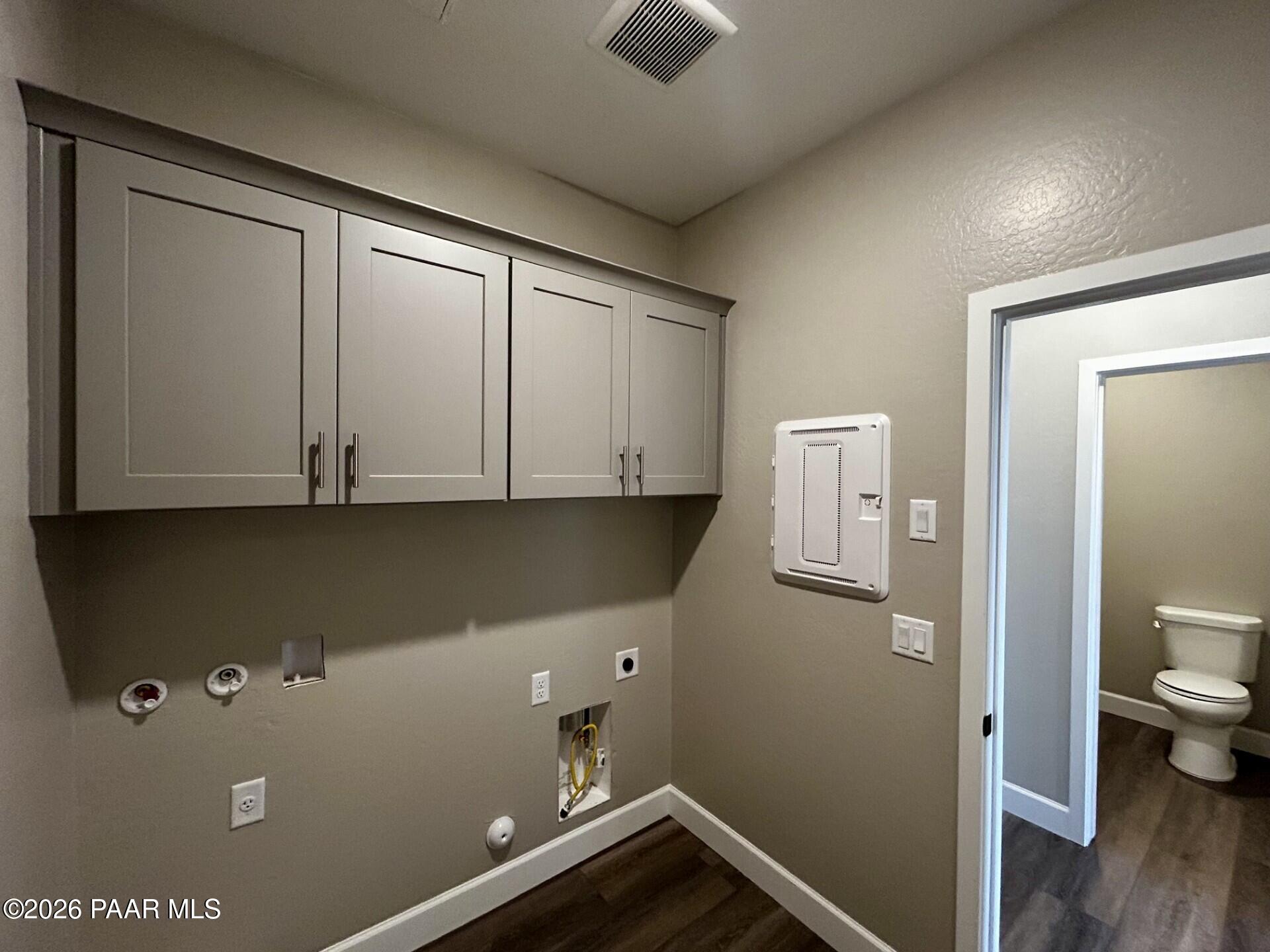 Laundry room with grey cabinets and washer-dryer hookups in The Harmony C floor plan at Pronghorn Ranch, Prescott Valley.