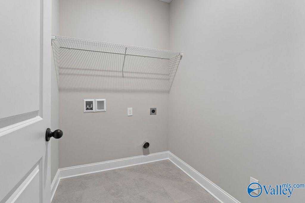 Functional laundry room with wire shelving, electrical outlets, and dryer hookup in Davidson Homes The Montgomery B, Hartselle, Alabama
