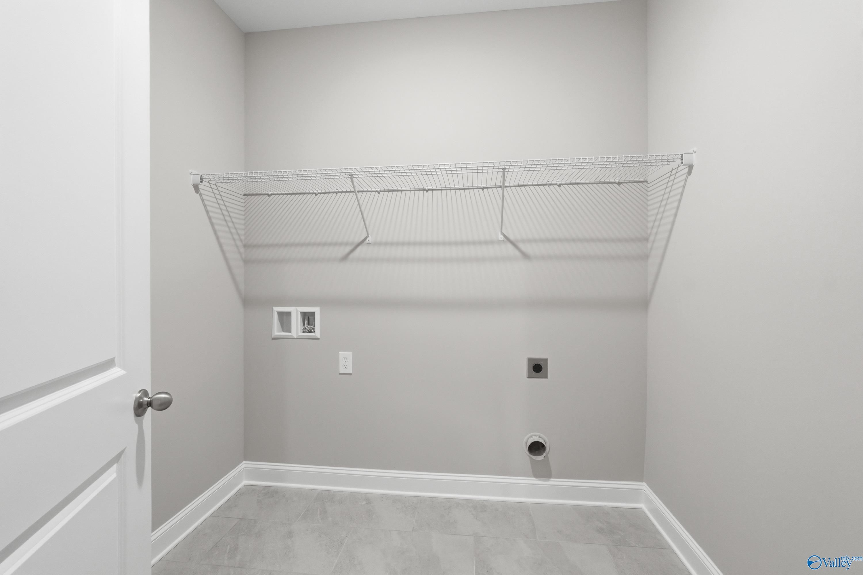 Spacious laundry room with wire shelving, washer/dryer outlets in The Lanier floor plan, Davidson Homes, Toney, Alabama